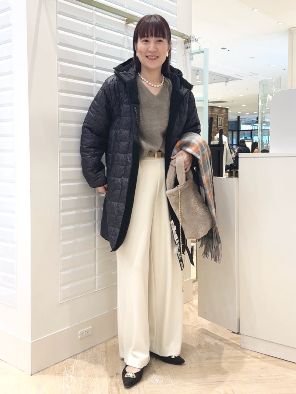 ホワイト系のその他パンツ、ベージュ系のトートバッグ、ブラック系のダウンジャケット/コートを着用したレディースの秋コーディネートの6枚目の写真