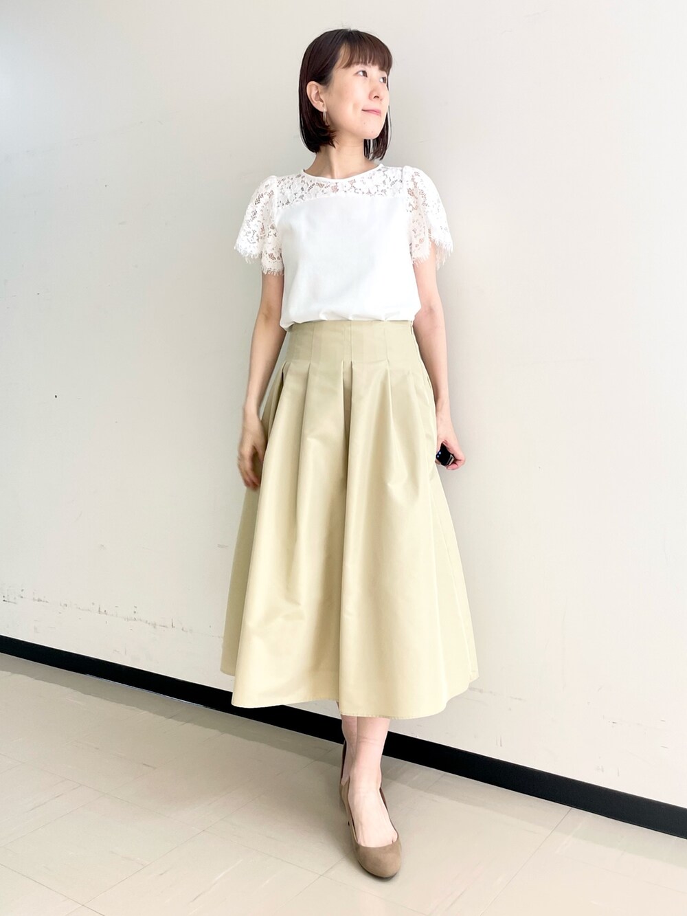 ベージュ系のスカート、ホワイト系のノーカラージャケット、ホワイト系のニット/セーターを着用したレディースの春コーディネートの5枚目の写真