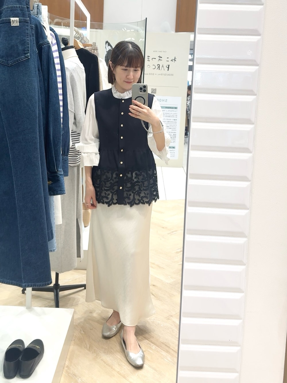 ホワイト系のスカート、ブルー系のベスト、ホワイト系のシャツ/ブラウスを着用したレディースの春コーディネートの2枚目の写真