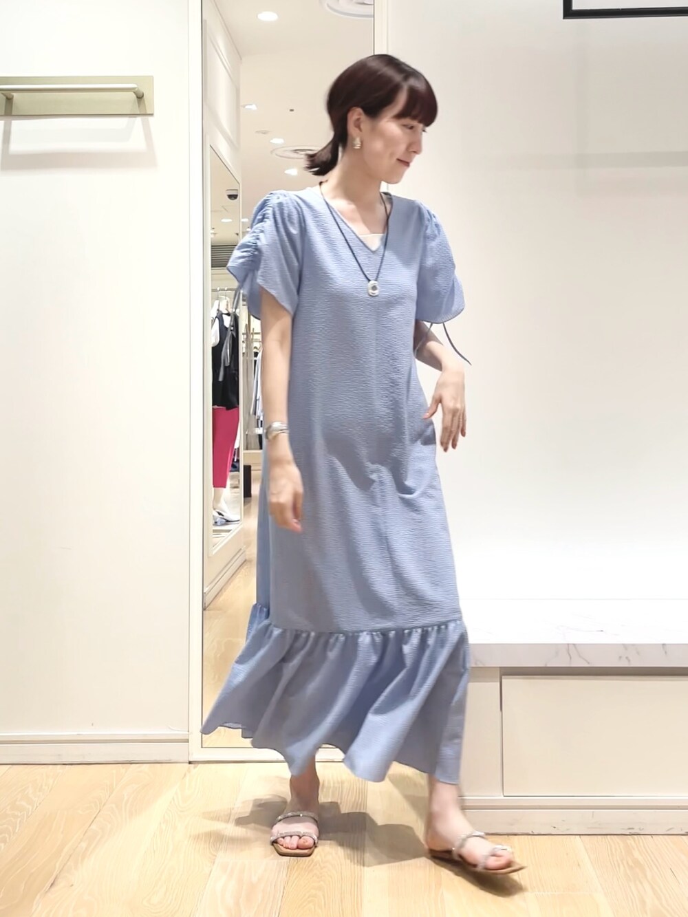 ブルー系のワンピース、グリーン系のバンダナ/スカーフ、ゴールド系のイヤリングを着用したレディースの春コーディネートの7枚目の写真