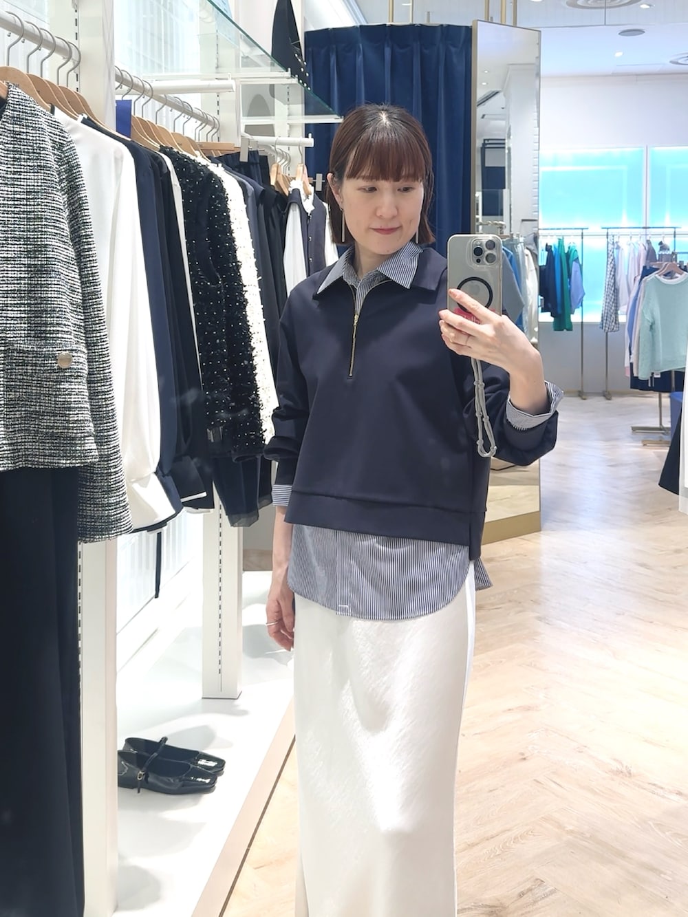 ホワイト系のスカート、ブルー系のスウェット、ブルー系のシャツ/ブラウスを着用したレディースの春コーディネートの4枚目の写真