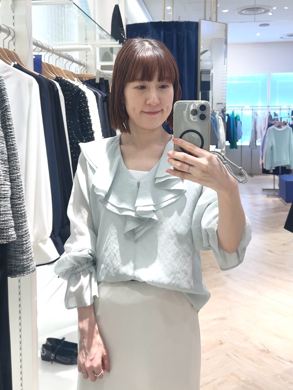 ホワイト系のスカート、グリーン系のシャツ/ブラウス、ホワイト系のタンクトップを着用したレディースの春コーディネートの2枚目の写真