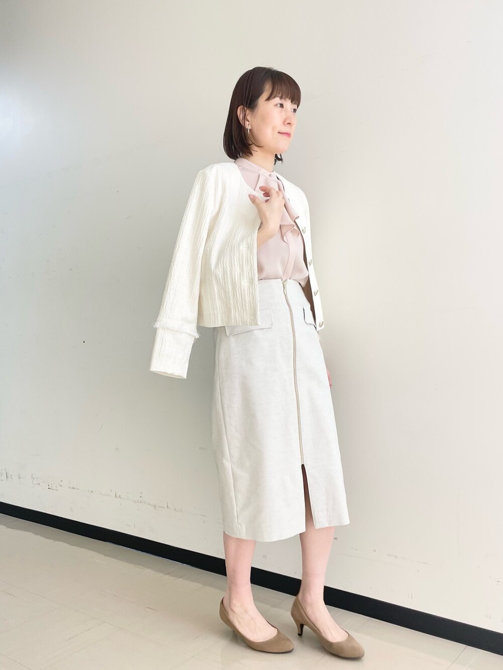 ベージュ系のスカート、ホワイト系のノーカラージャケット、ピンク系のシャツ/ブラウスを着用したレディースの春コーディネートの5枚目の写真
