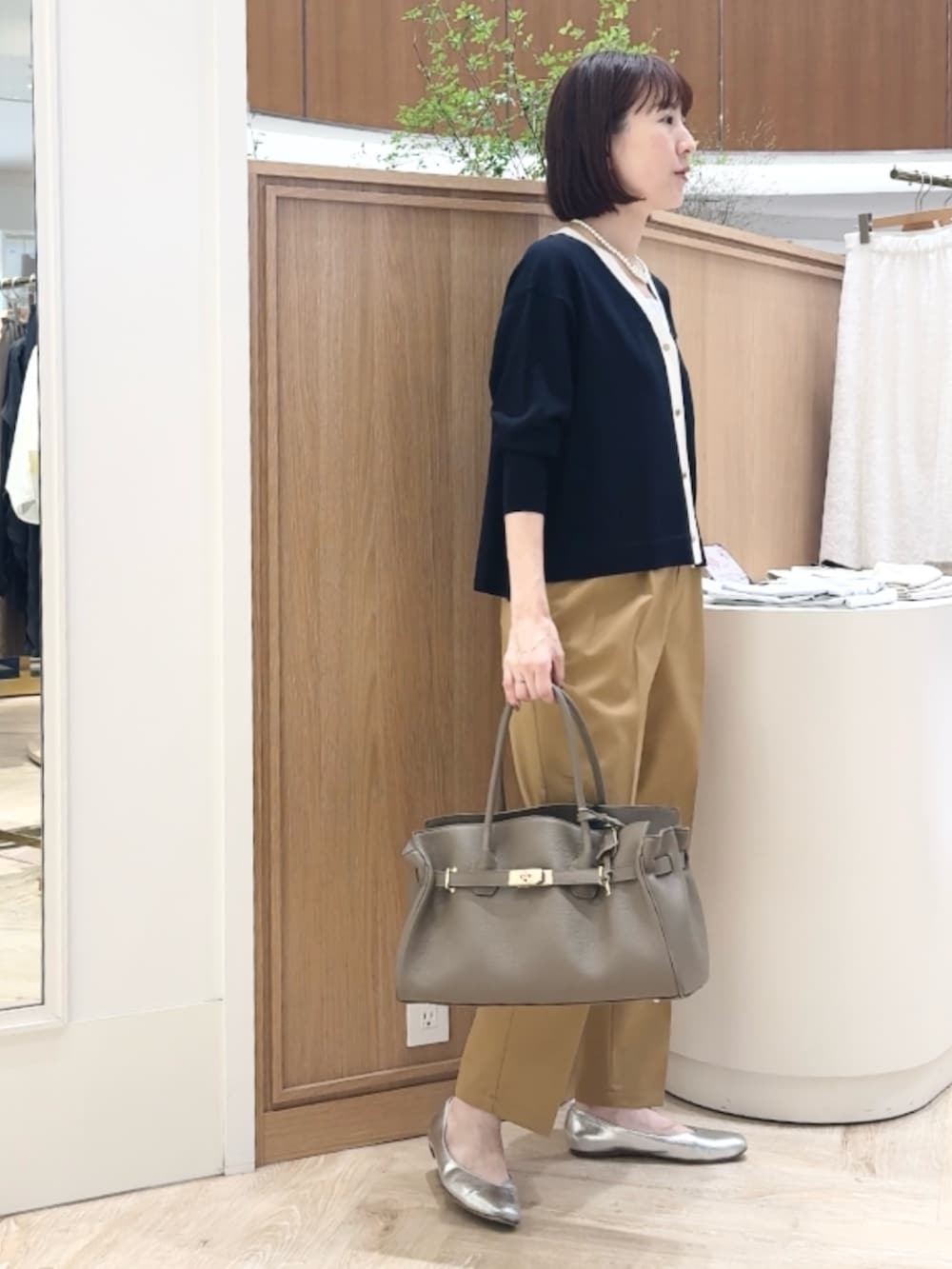 ブルー系のカーディガン/ボレロ、イエロー系のその他パンツ、ベージュ系のトートバッグを着用したレディースの秋コーディネートの6枚目の写真