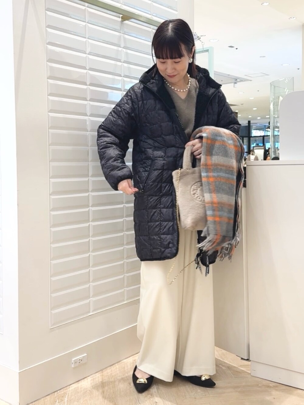 ホワイト系のその他パンツ、ベージュ系のトートバッグ、ブラック系のダウンジャケット/コートを着用したレディースの秋コーディネートの5枚目の写真