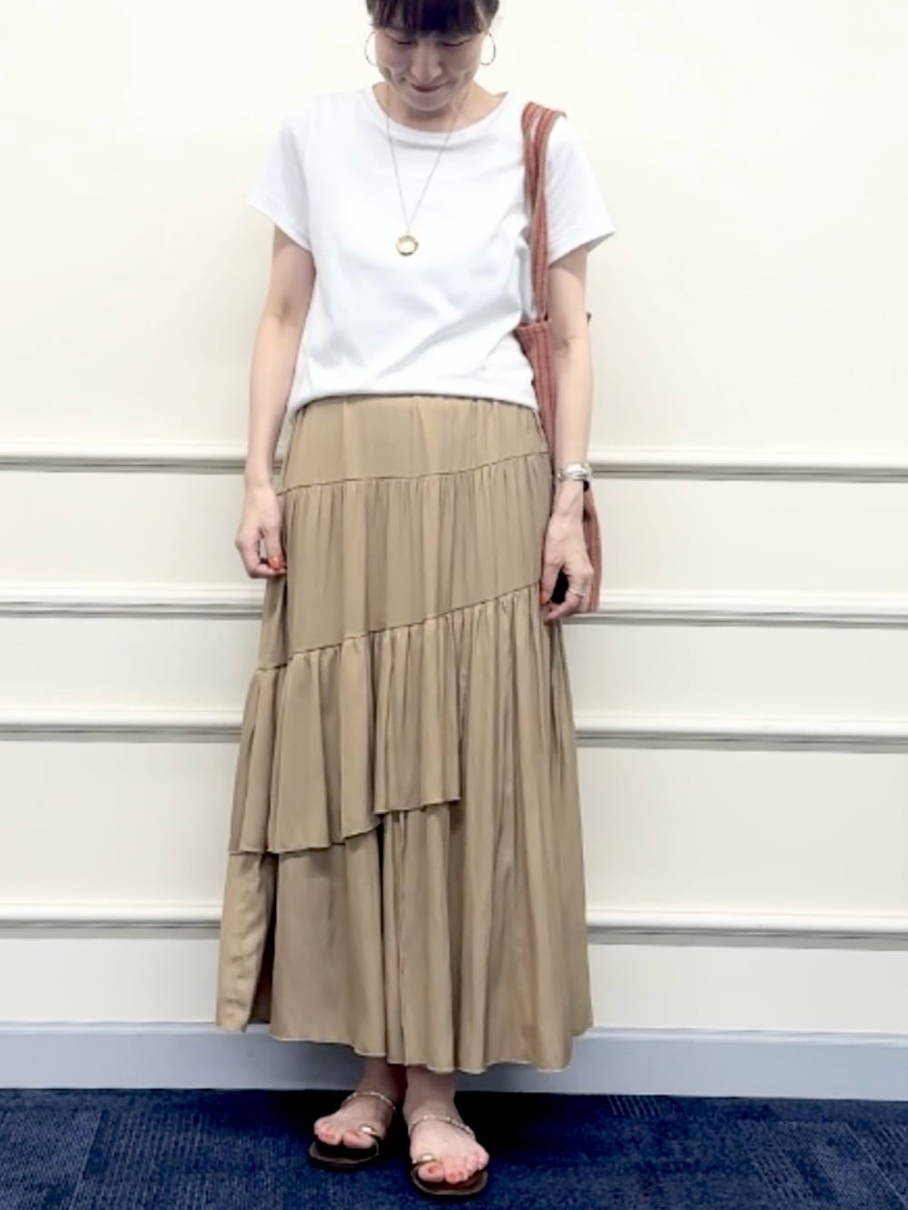 レッド系のトートバッグ、イエロー系のスカート、ホワイト系のTシャツ/カットソーを着用したレディースの夏コーディネートの7枚目の写真