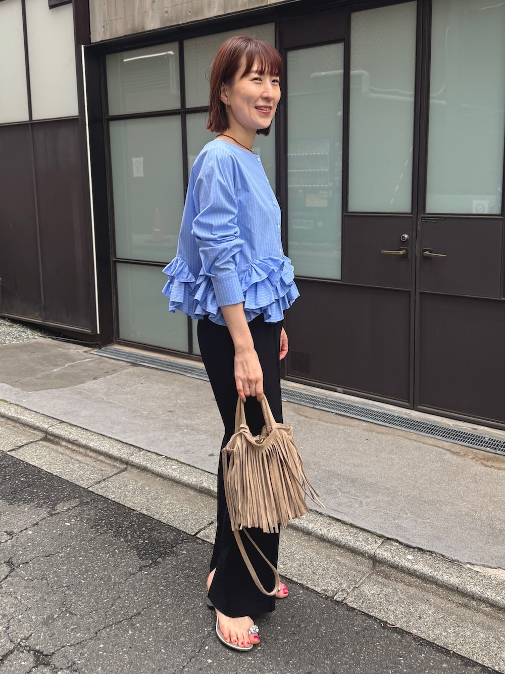 ブルー系のシャツ/ブラウス、ブラック系のその他パンツ、ベージュ系のショルダーバッグを着用したレディースの春コーディネートの4枚目の写真