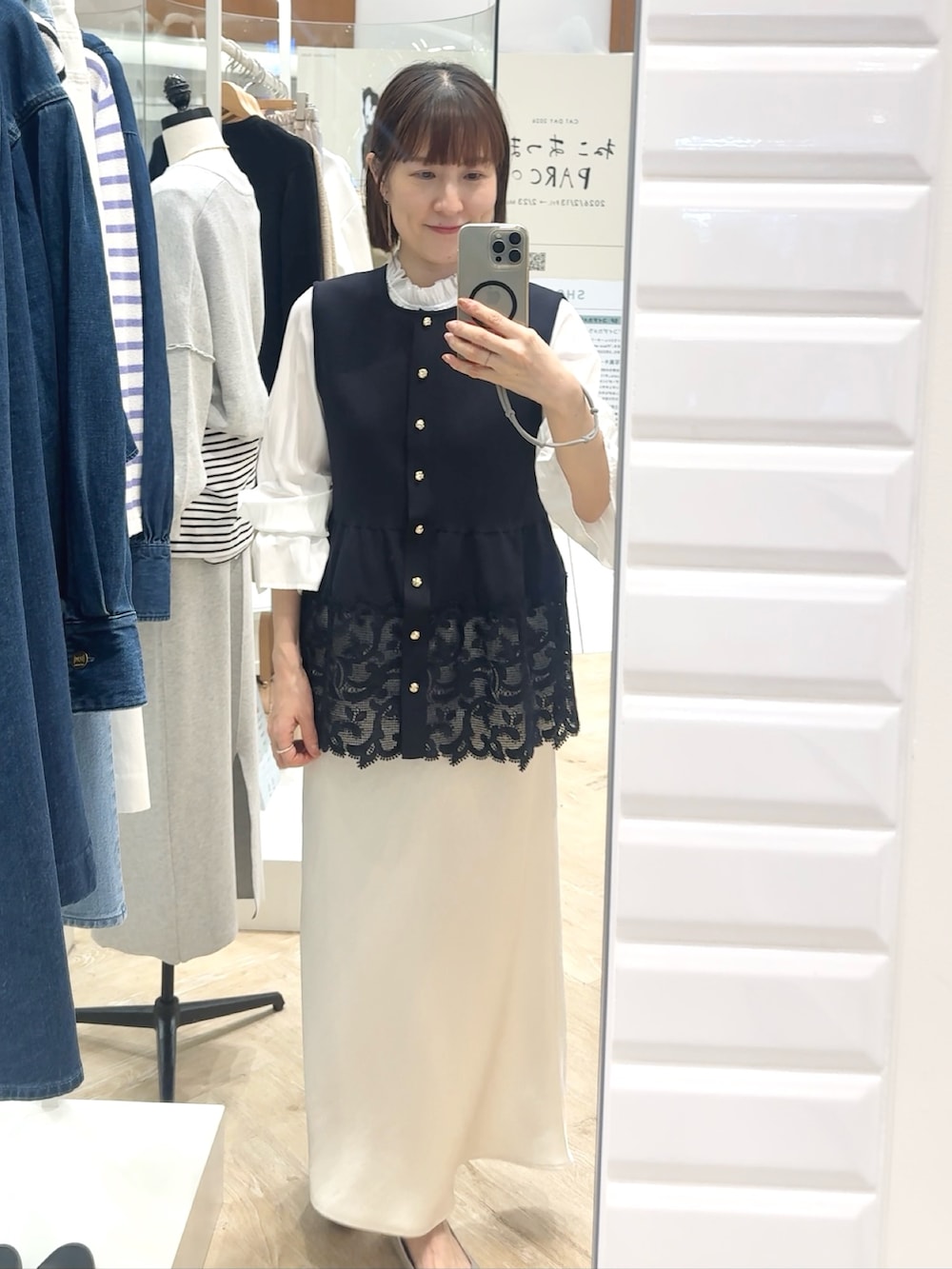 ホワイト系のスカート、ブルー系のベスト、ホワイト系のシャツ/ブラウスを着用したレディースの春コーディネートの7枚目の写真