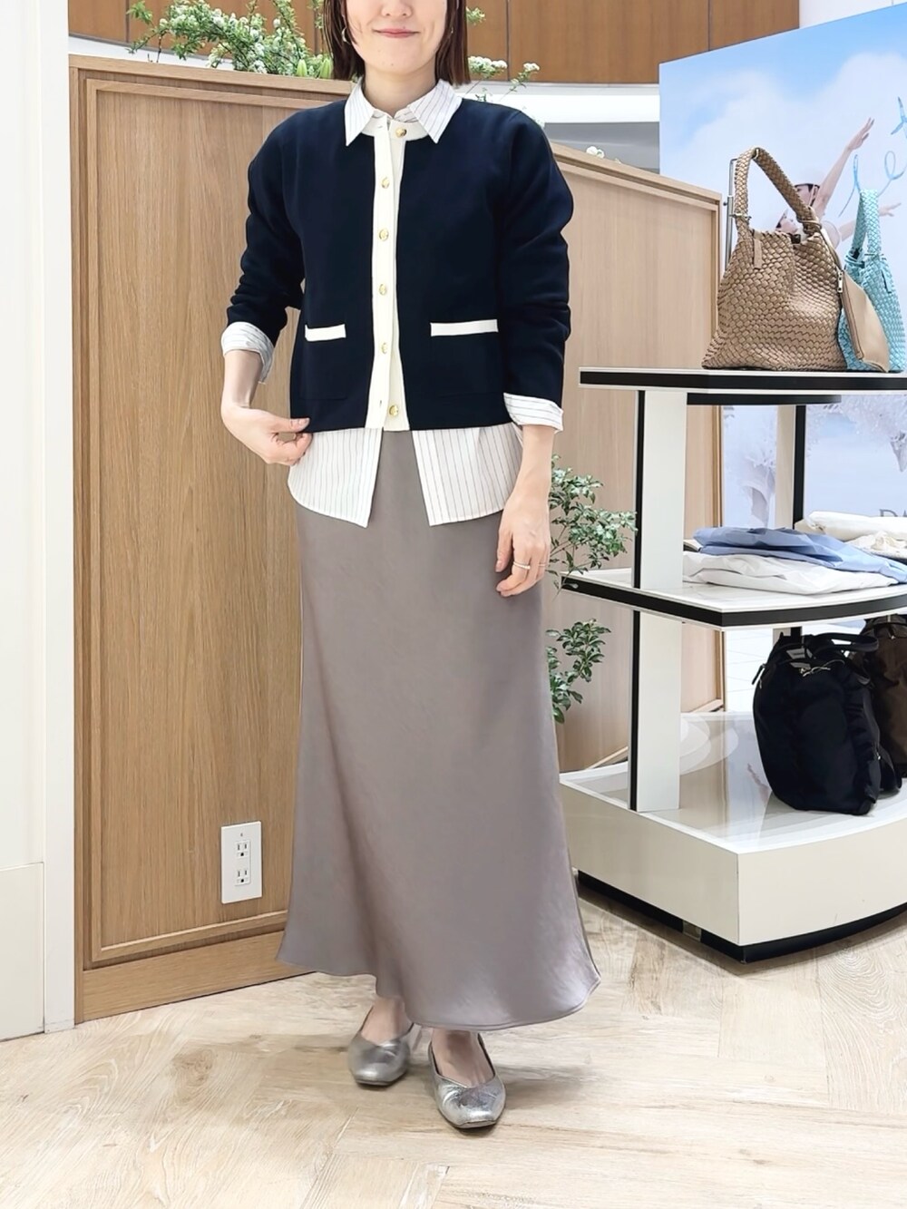 グリーン系のスカート、ベージュ系のトートバッグ、ブルー系のカーディガン/ボレロを着用したレディースの春コーディネートの4枚目の写真