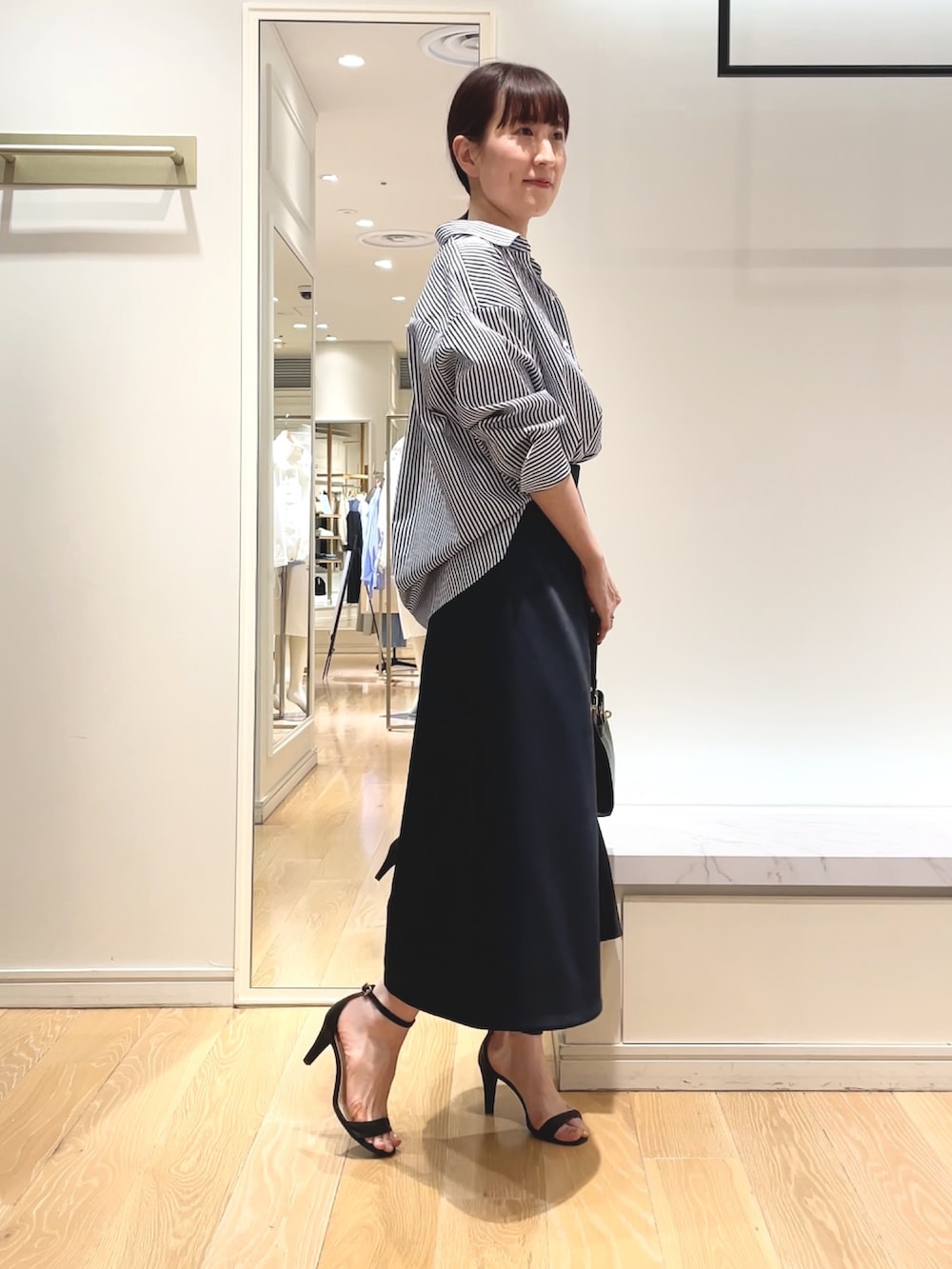 ホワイト系のシャツ/ブラウス、ブルー系のスカート、ブラック系のショルダーバッグを着用したレディースの春コーディネートの9枚目の写真