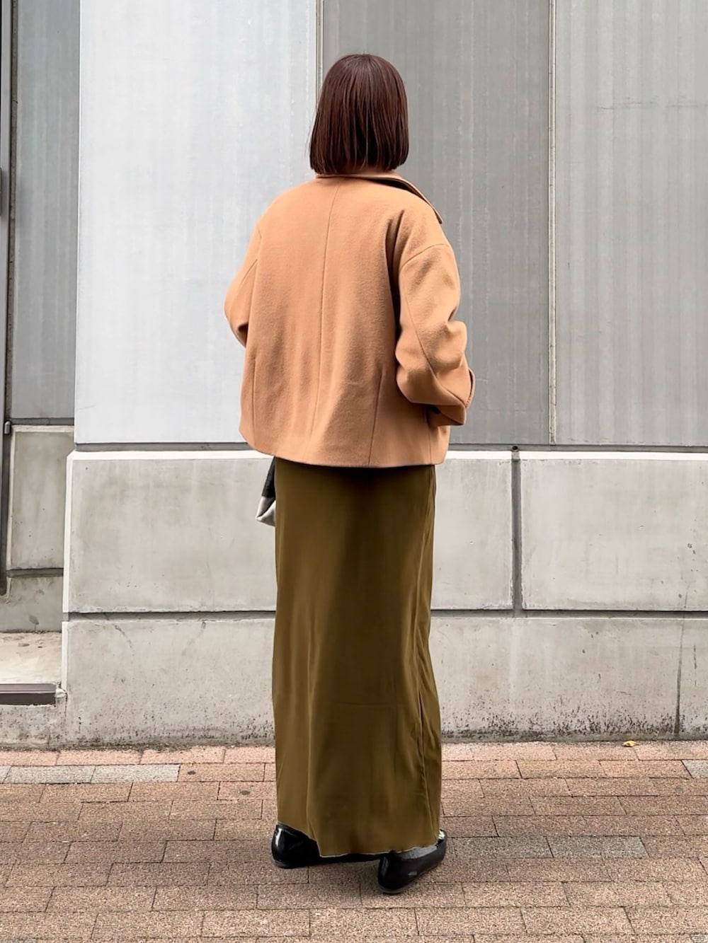 グリーン系のスカート、ホワイト系のニット/セーター、イエロー系のピーコートを着用したレディースの秋コーディネートの5枚目の写真