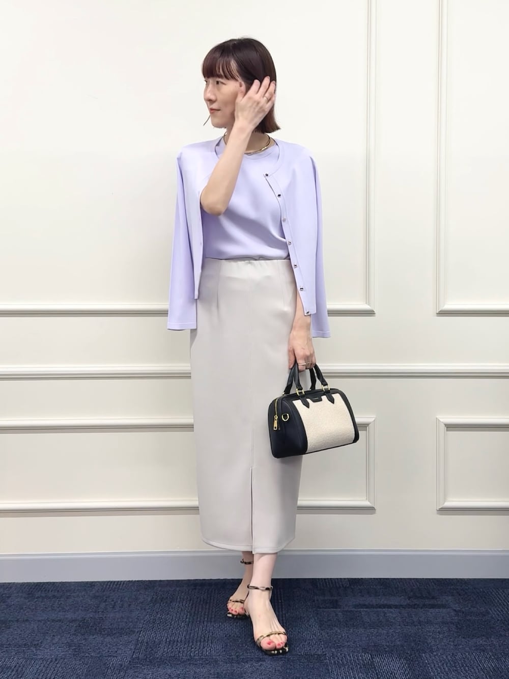 ブラック系のボストンバッグ、パープル系のカーディガン/ボレロ、パープル系のニット/セーターを着用したレディースの春コーディネートの7枚目の写真