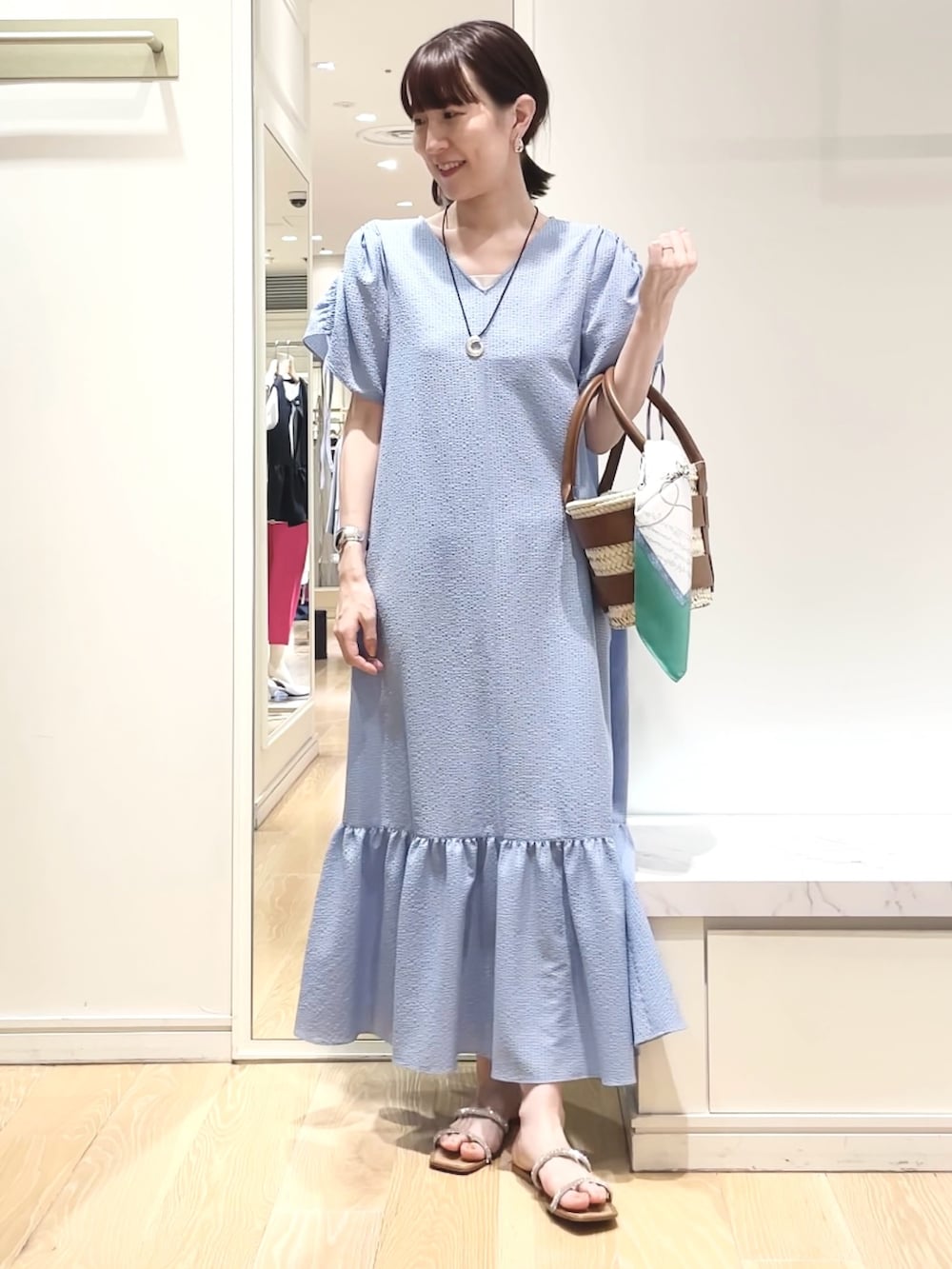 ブルー系のワンピース、グリーン系のバンダナ/スカーフ、ゴールド系のイヤリングを着用したレディースの春コーディネートの2枚目の写真