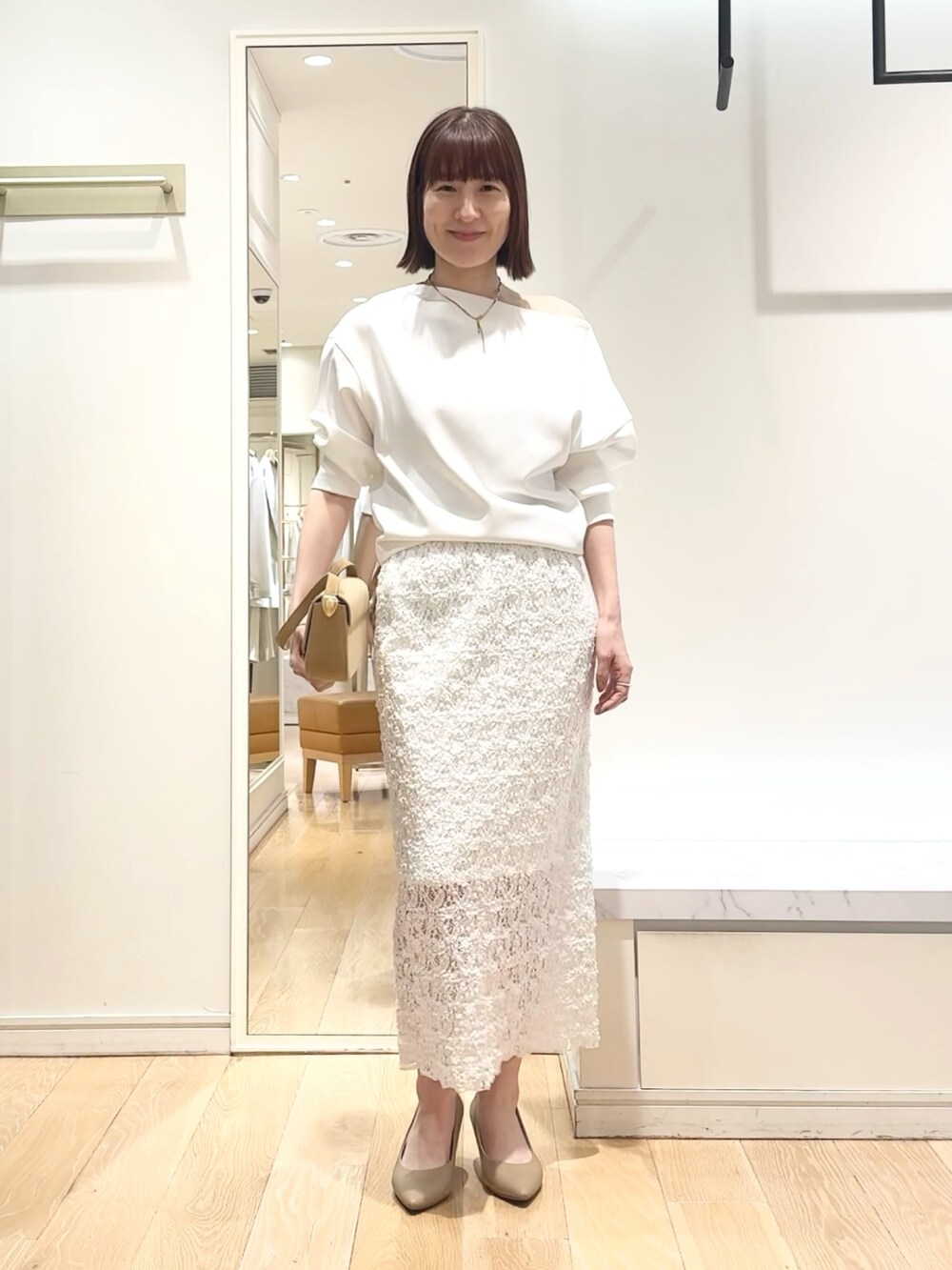 ホワイト系のTシャツ/カットソー、ホワイト系のスカート、ゴールド系のネックレスを着用したレディースの春コーディネートの5枚目の写真