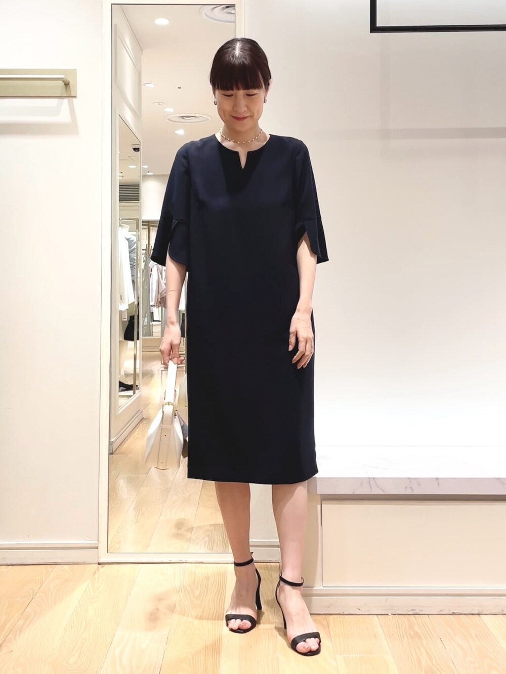 ブルー系のワンピース、ホワイト系のショルダーバッグ、シルバー系のイヤリングを着用したレディースの春コーディネートの5枚目の写真