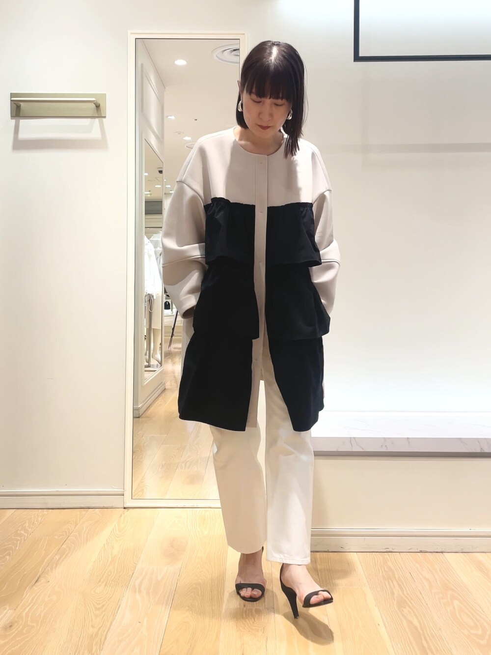 ベージュ系のその他アウター、ブラック系のショルダーバッグを着用したレディースの春コーディネートの6枚目の写真