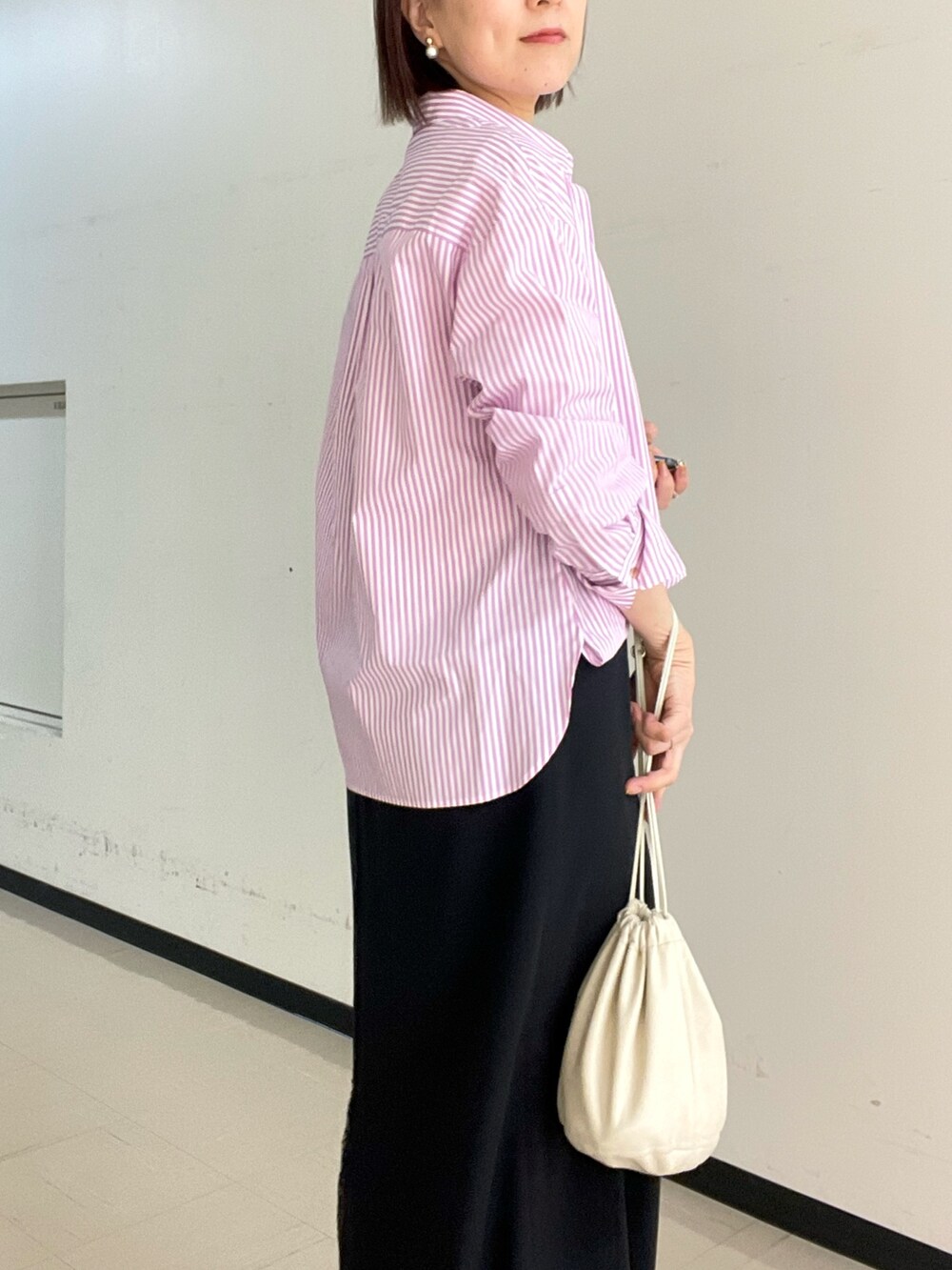 ブラック系のスカート、ホワイト系のニット/セーター、ピンク系のシャツ/ブラウスを着用したレディースの冬コーディネートの3枚目の写真