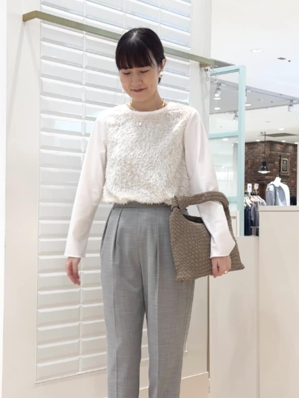 グレー系のその他パンツ、ホワイト系のシャツ/ブラウス、グレー系のショルダーバッグを着用したレディースの冬コーディネートの7枚目の写真