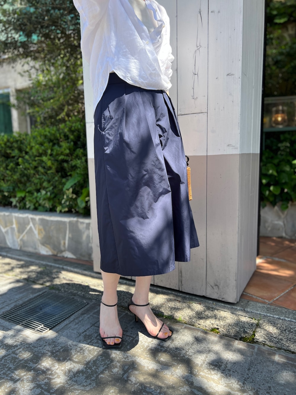 イエロー系のかごバッグ、ブルー系のその他パンツ、ホワイト系のシャツ/ブラウスを着用したレディースの夏コーディネートの3枚目の写真