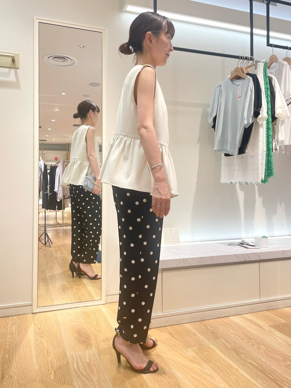 ホワイト系のベスト、ブラック系のその他パンツ、ブルー系のショルダーバッグを着用したレディースの夏コーディネートの7枚目の写真