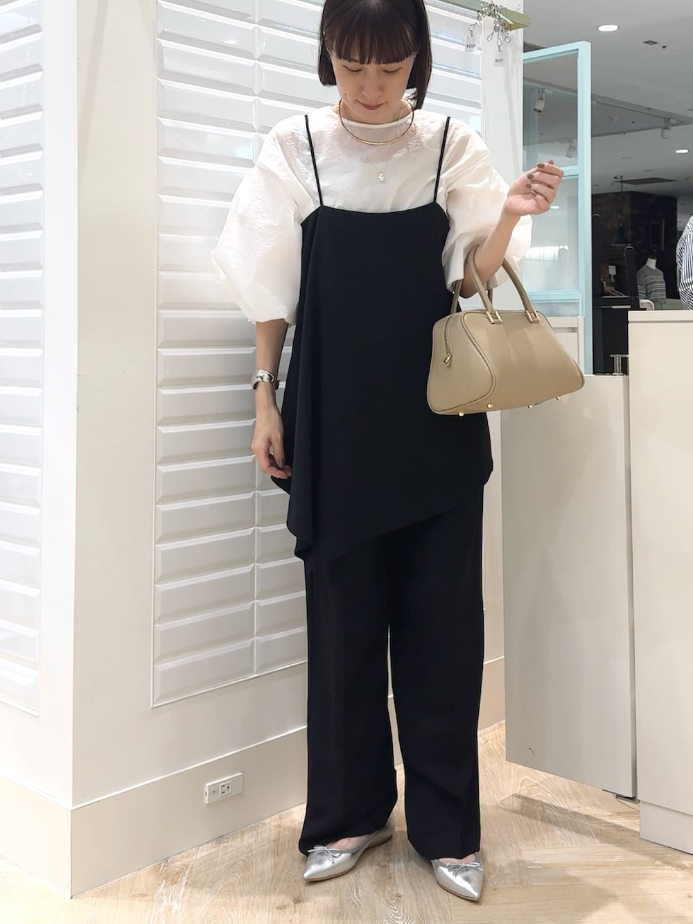 ブラック系のその他パンツ、ホワイト系のシャツ/ブラウス、ベージュ系のショルダーバッグを着用したレディースの秋コーディネートの3枚目の写真