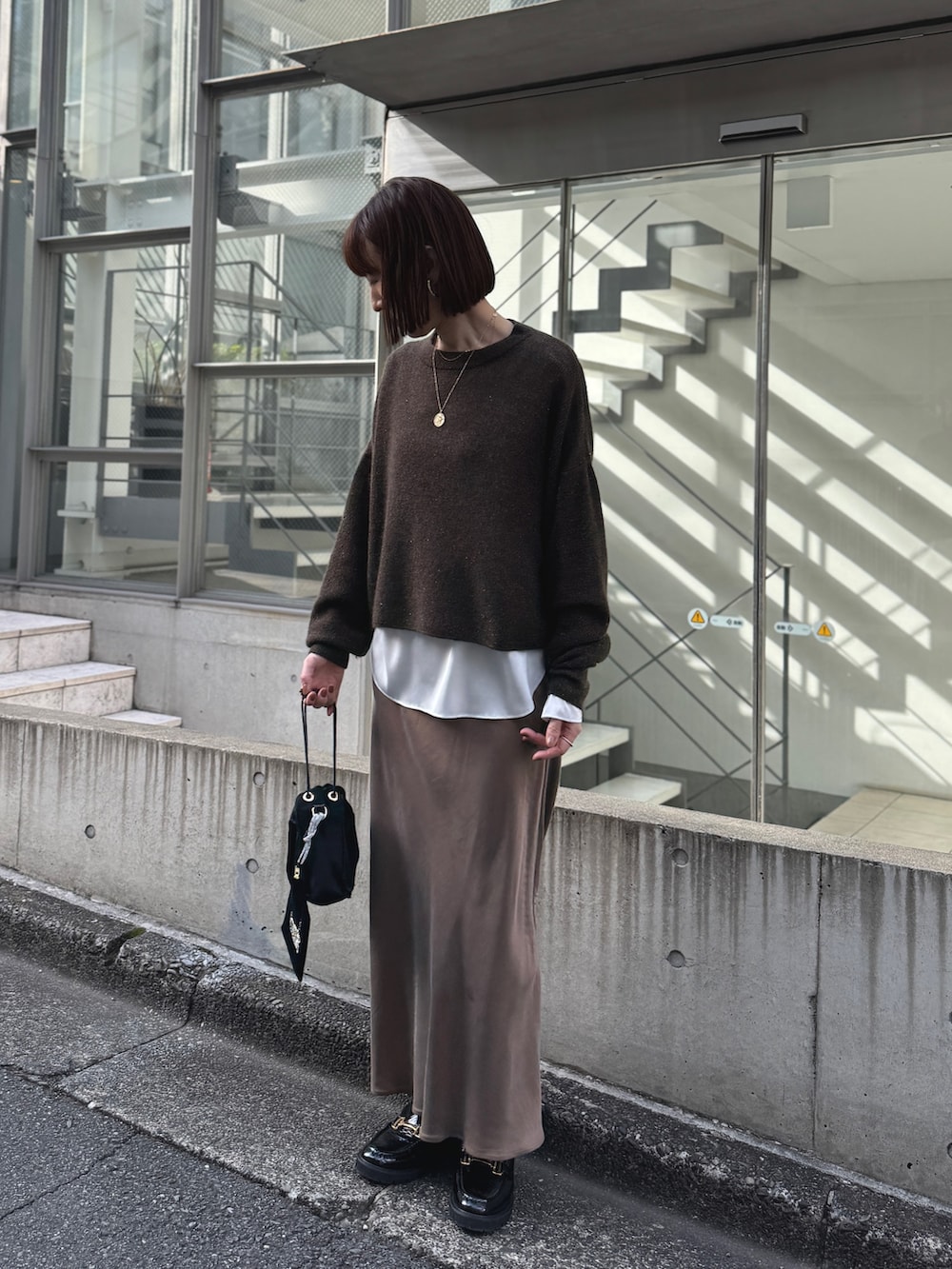 ホワイト系のシャツ/ブラウス、ブラウン系のニット/セーター、ブラック系のその他シューズを着用したレディースの冬コーディネートの9枚目の写真