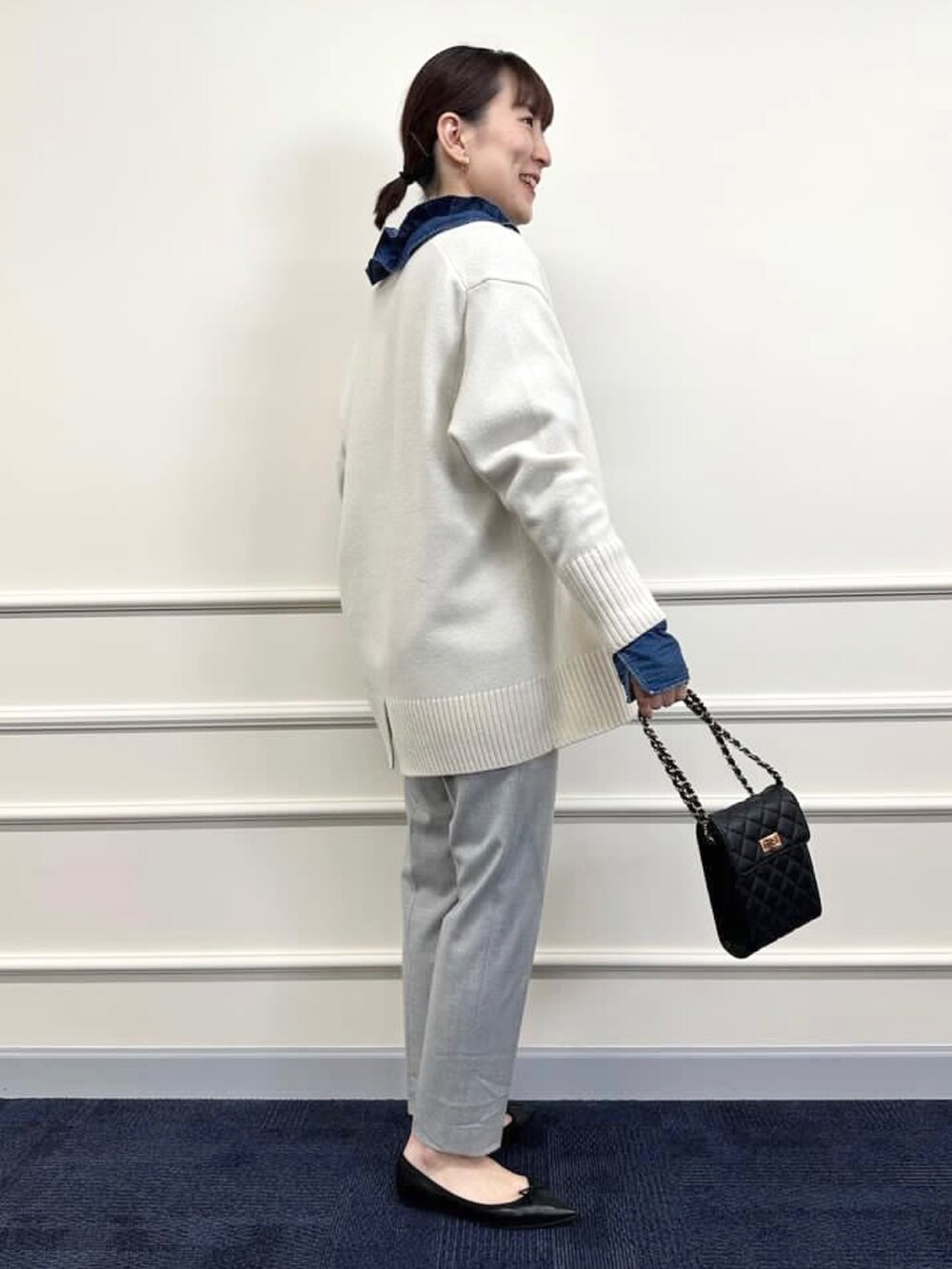 ブラック系のパンプス、グレー系のその他パンツ、ホワイト系のカーディガン/ボレロを着用したレディースの冬コーディネートの4枚目の写真