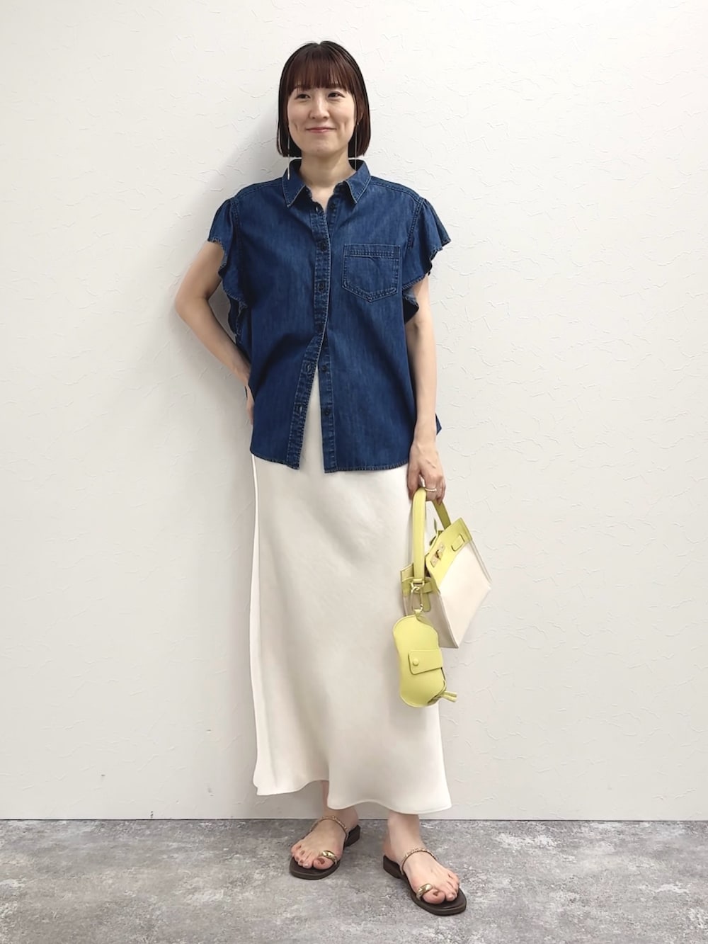 ブルー系のシャツ/ブラウス、イエロー系のショルダーバッグ、ホワイト系のスカートを着用したレディースの冬コーディネートの4枚目の写真