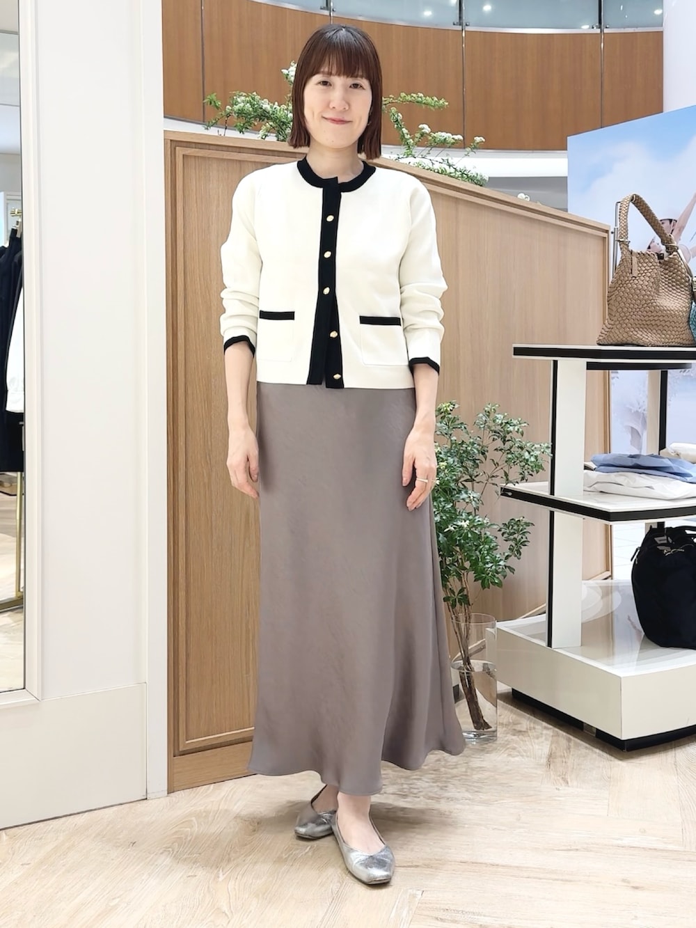 ベージュ系のトートバッグ、ホワイト系のシャツ/ブラウス、グリーン系のスカートを着用したレディースの春コーディネートの7枚目の写真