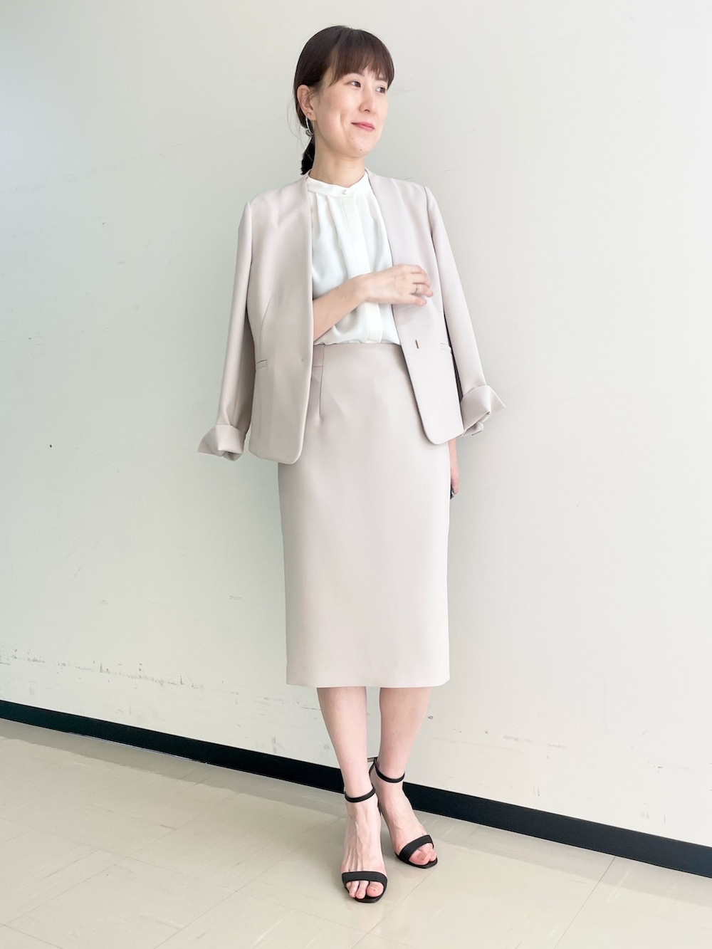 ベージュ系のスカート、ホワイト系のシャツ/ブラウス、ベージュ系のノーカラージャケットを着用したレディースの春コーディネートの5枚目の写真