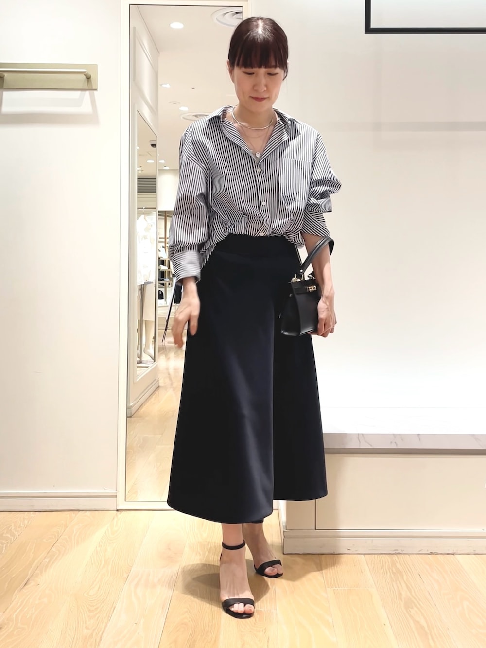 ホワイト系のシャツ/ブラウス、ブルー系のスカート、ブラック系のショルダーバッグを着用したレディースの春コーディネートの8枚目の写真