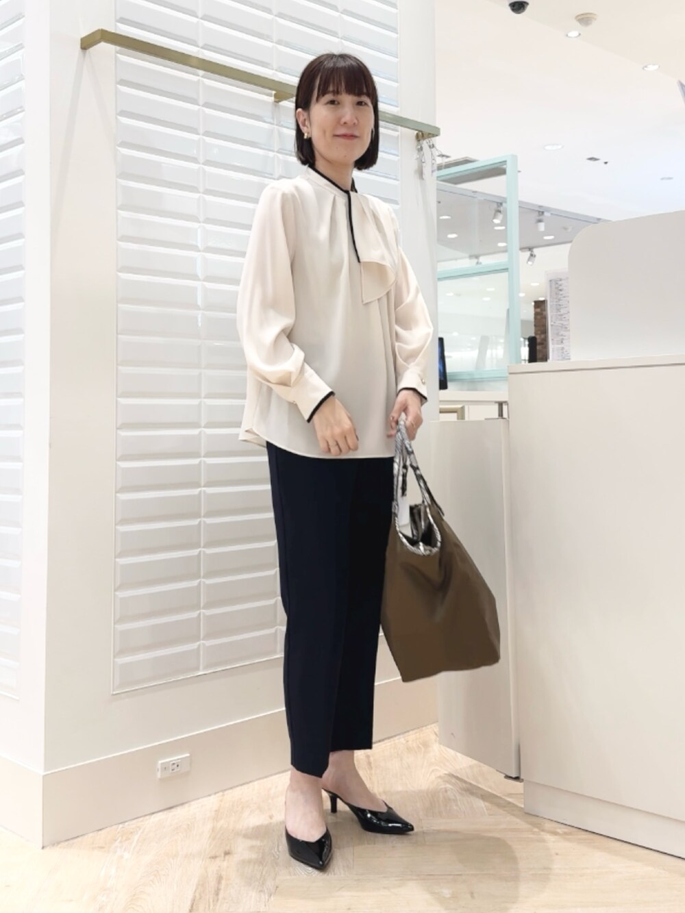ブルー系のその他パンツ、ブラウン系のトートバッグ、ホワイト系のシャツ/ブラウスを着用したレディースの秋コーディネートの5枚目の写真