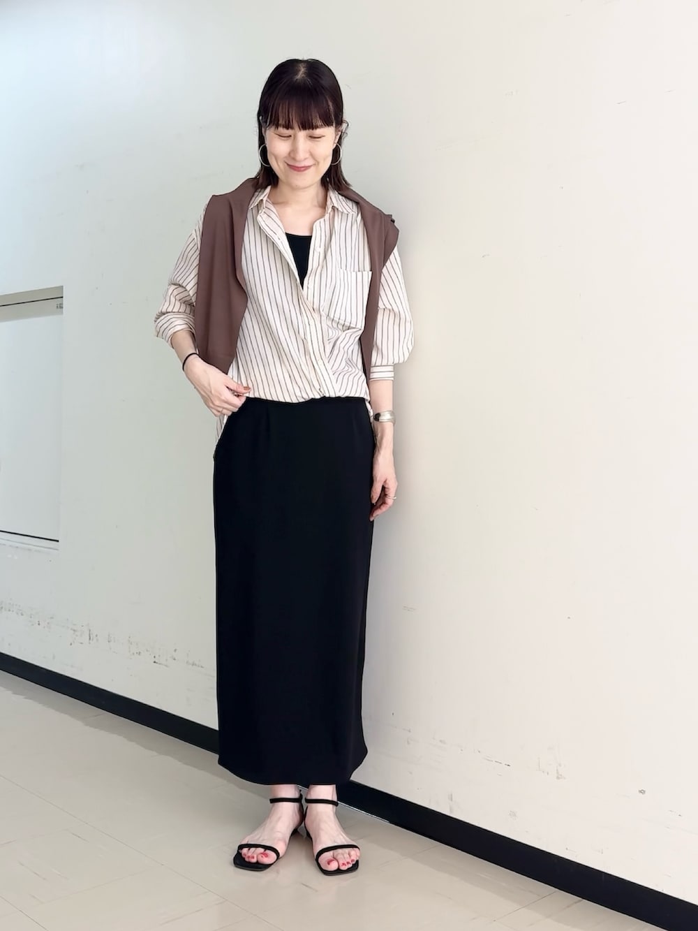 ブラック系のスカート、ブラウン系のカーディガン/ボレロ、ピンク系のシャツ/ブラウスを着用したレディースの春コーディネートの7枚目の写真