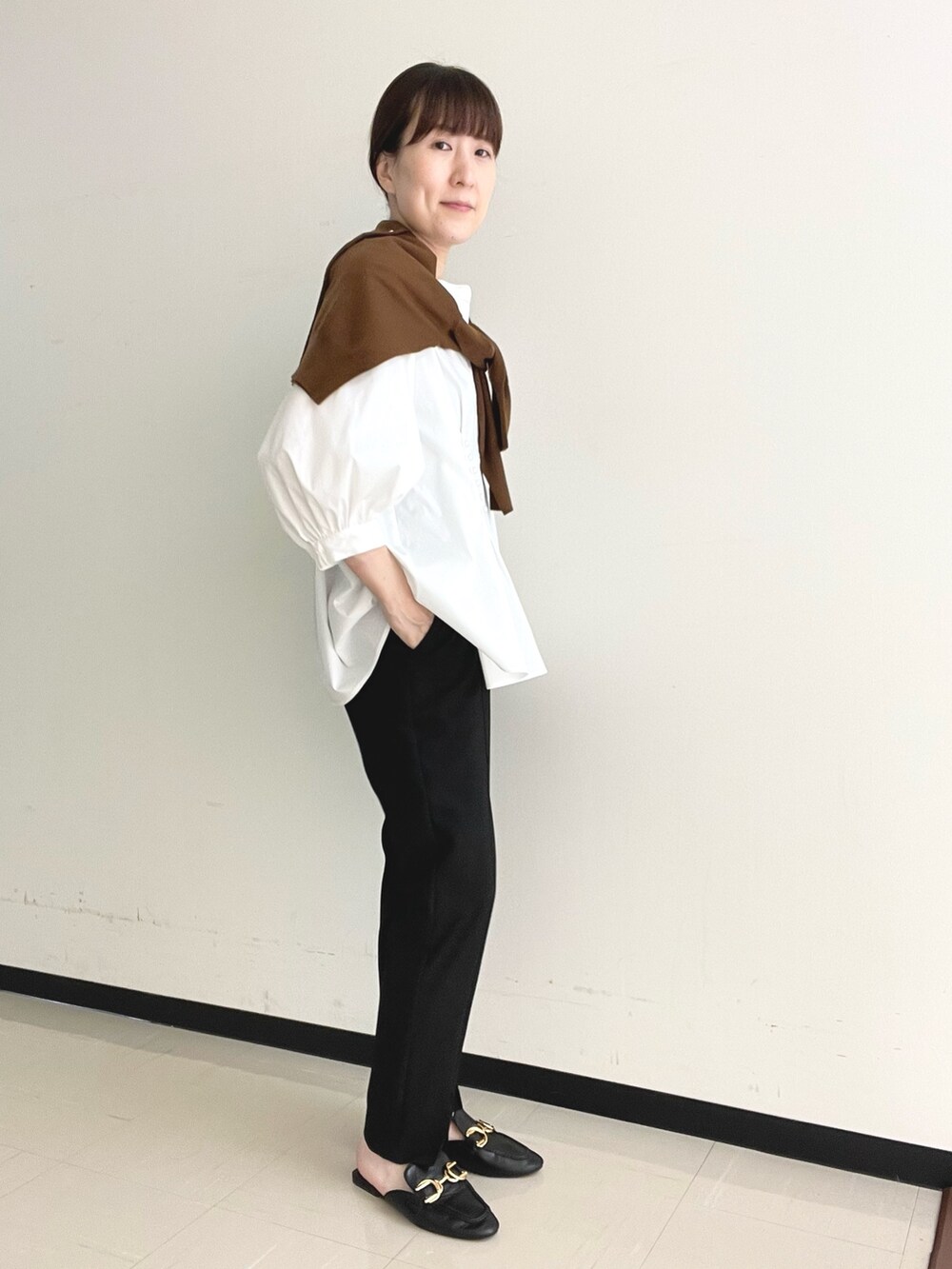 ブラック系のその他パンツ、ブルー系のショルダーバッグ、ホワイト系のシャツ/ブラウスを着用したレディースの秋コーディネートの4枚目の写真