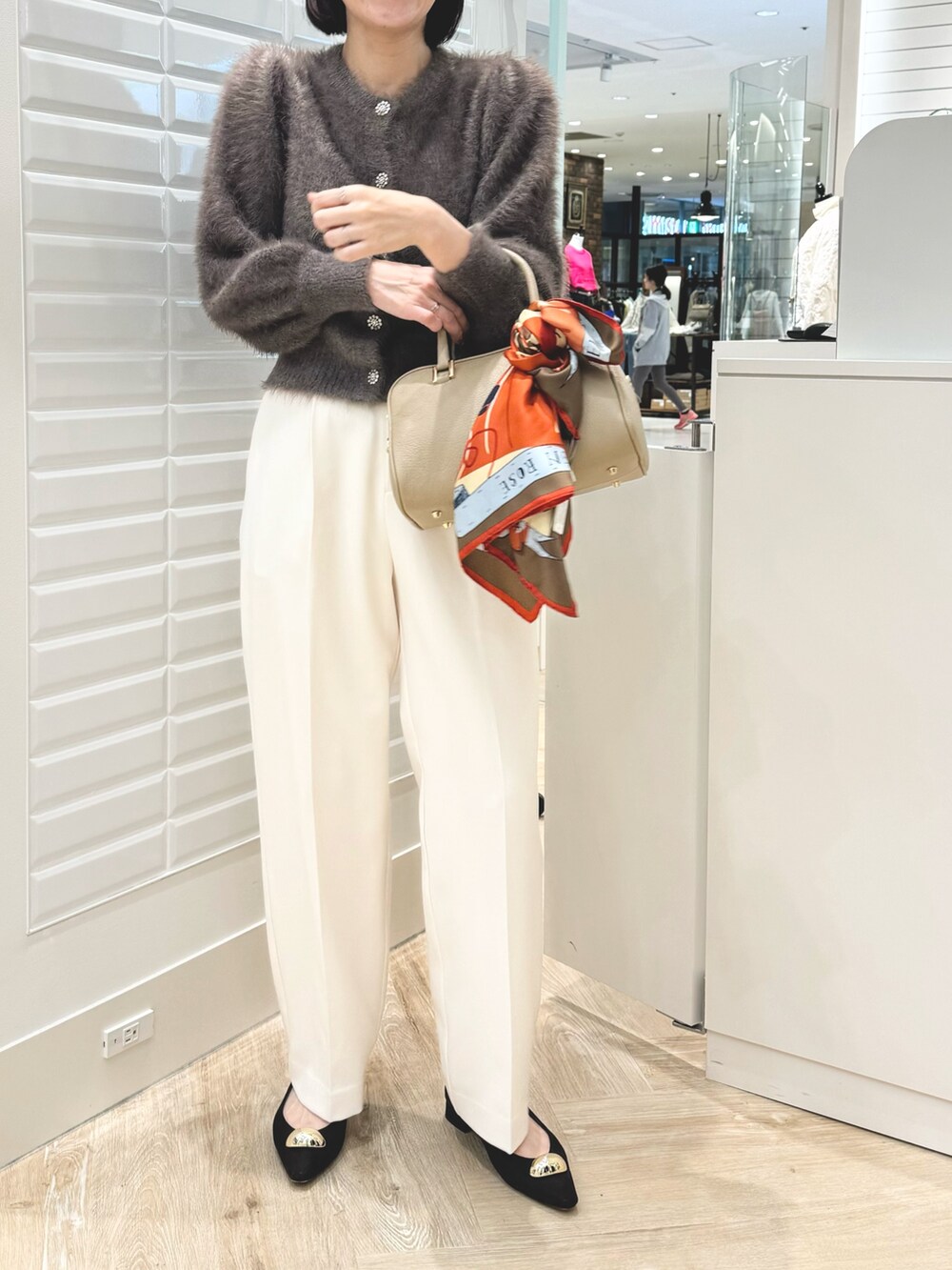 ベージュ系のショルダーバッグ、ブラウン系のカーディガン/ボレロ、ホワイト系のその他パンツを着用したレディースの秋コーディネートの2枚目の写真