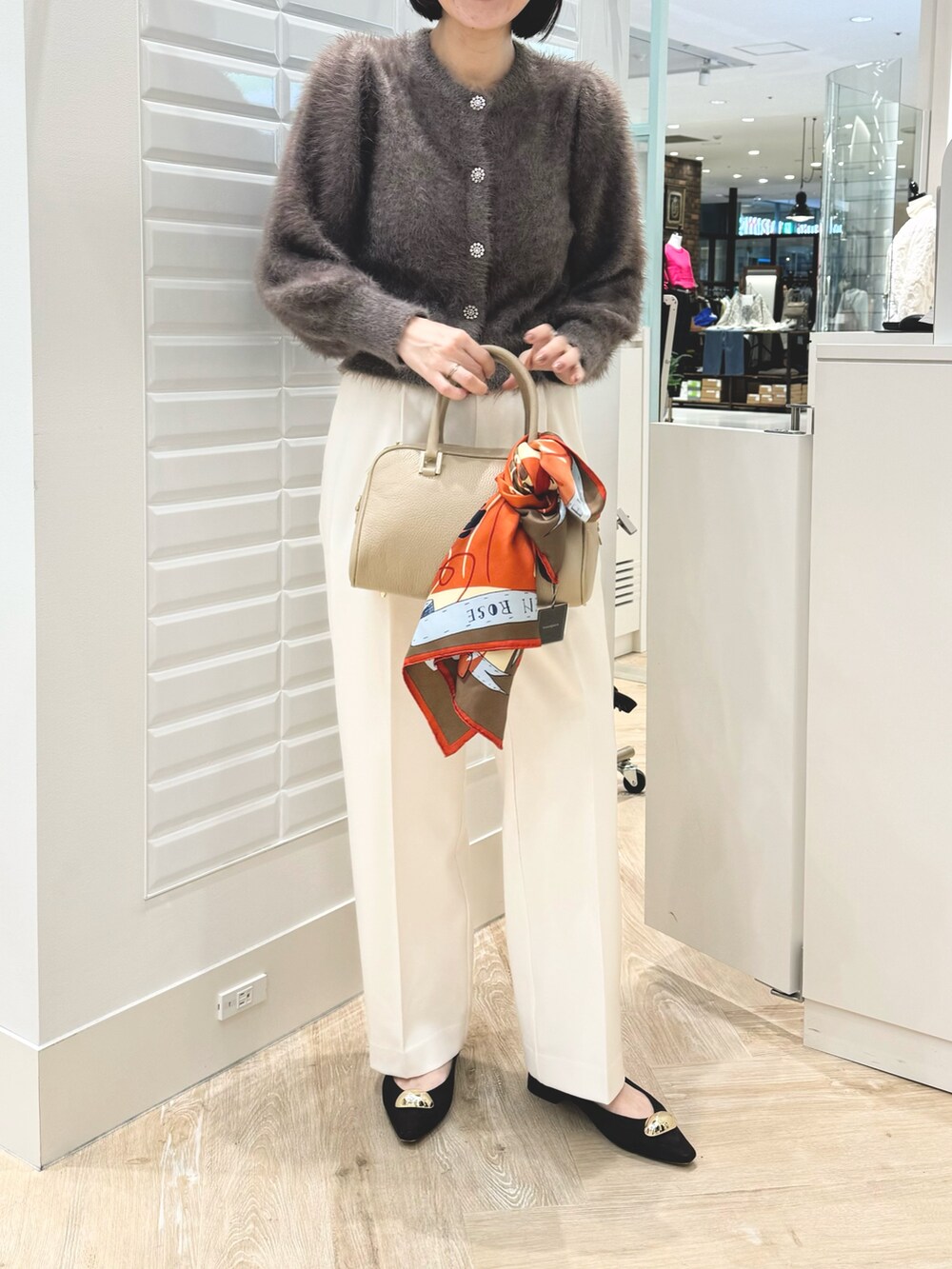ベージュ系のショルダーバッグ、ブラウン系のカーディガン/ボレロ、ホワイト系のその他パンツを着用したレディースの秋コーディネートの6枚目の写真