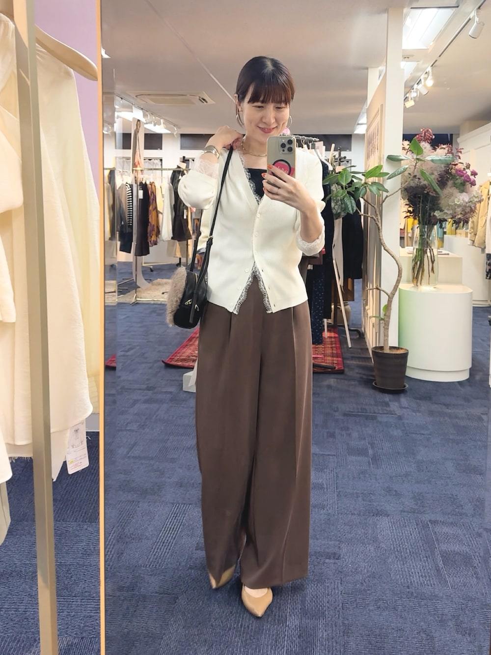 ブラウン系のショルダーバッグ、ホワイト系のカーディガン/ボレロ、ブラウン系のその他パンツを着用したレディースの秋コーディネートの5枚目の写真