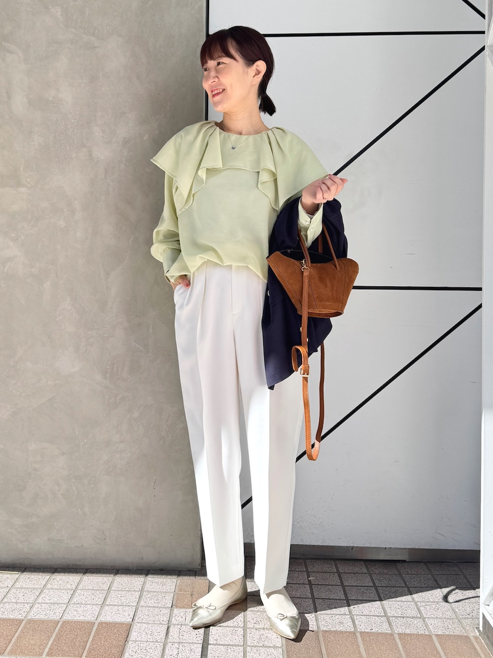 ホワイト系のその他パンツ、ブルー系のテーラードジャケット、イエロー系のトートバッグを着用したレディースの春コーディネートの2枚目の写真