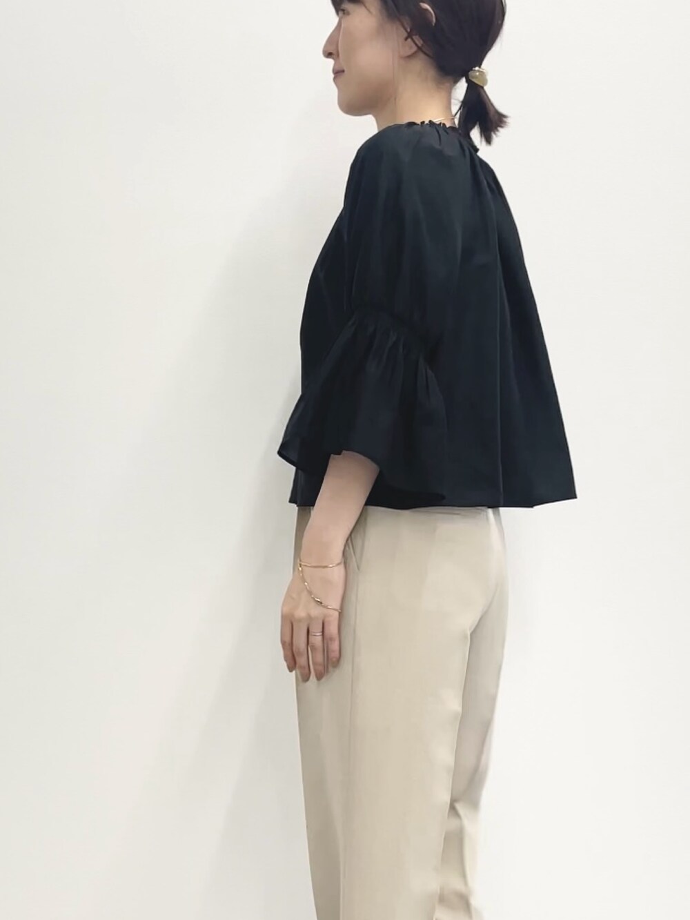 ベージュ系のその他パンツ、ベージュ系のニット/セーター、ブラック系のシャツ/ブラウスを着用したレディースの春コーディネートの6枚目の写真