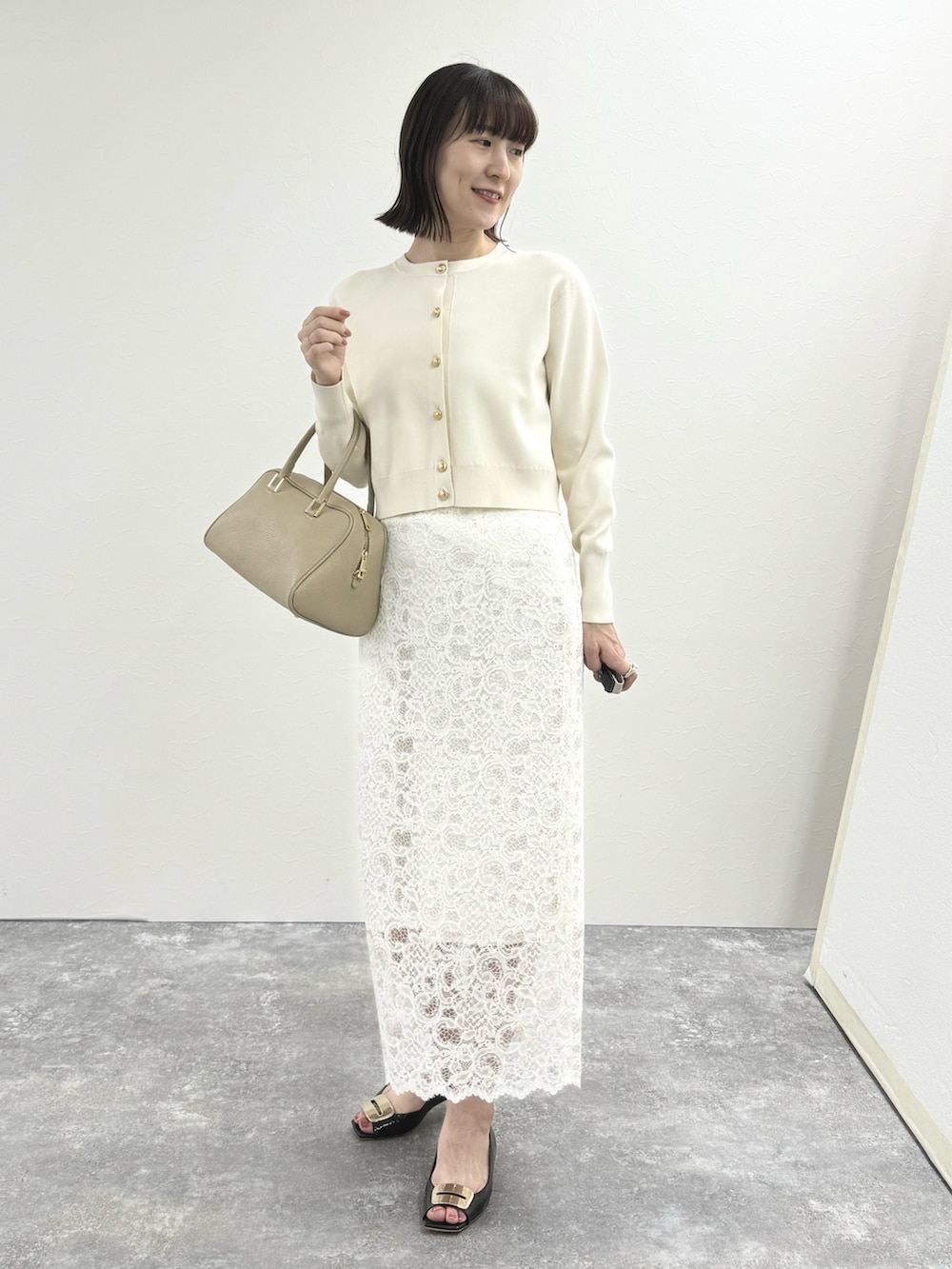 ホワイト系のカーディガン/ボレロ、ベージュ系のショルダーバッグ、ホワイト系のスカートを着用したレディースの秋コーディネートの10枚目の写真