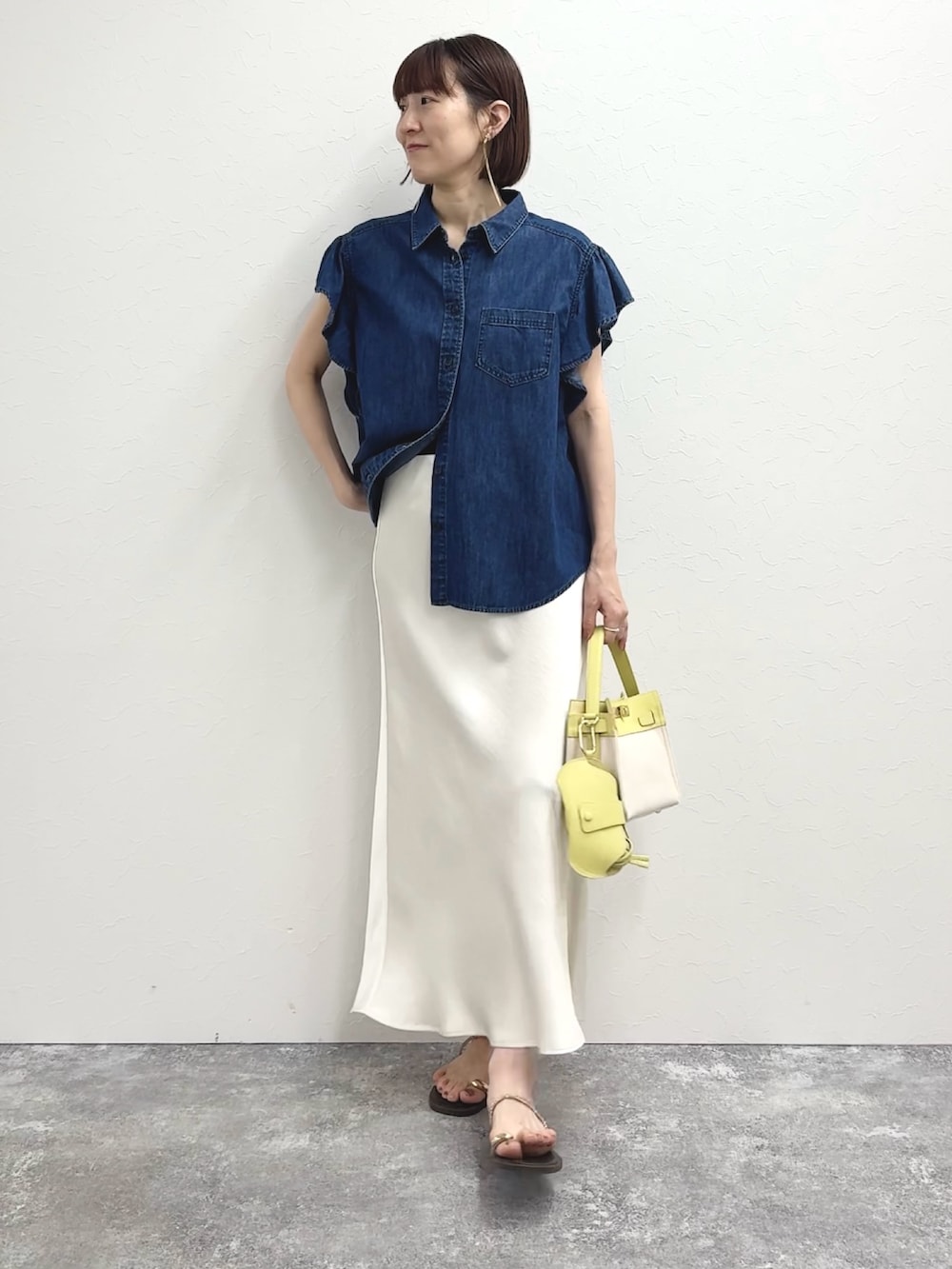 ブルー系のシャツ/ブラウス、イエロー系のショルダーバッグ、ホワイト系のスカートを着用したレディースの冬コーディネートの6枚目の写真