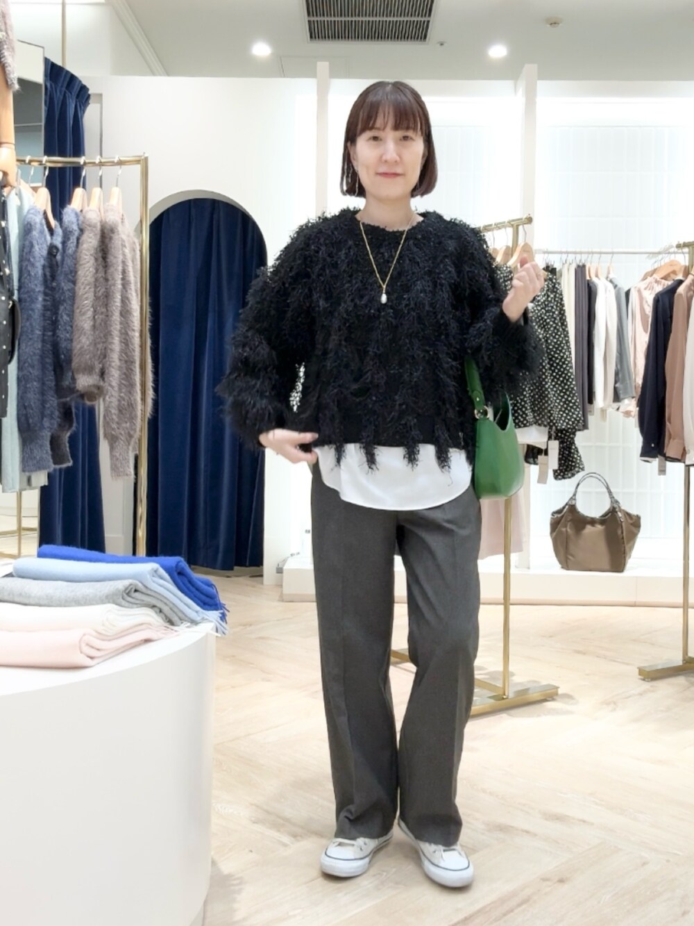 グレー系のその他パンツ、ホワイト系のシャツ/ブラウス、ブラック系のニット/セーターを着用したレディースの秋コーディネートの5枚目の写真