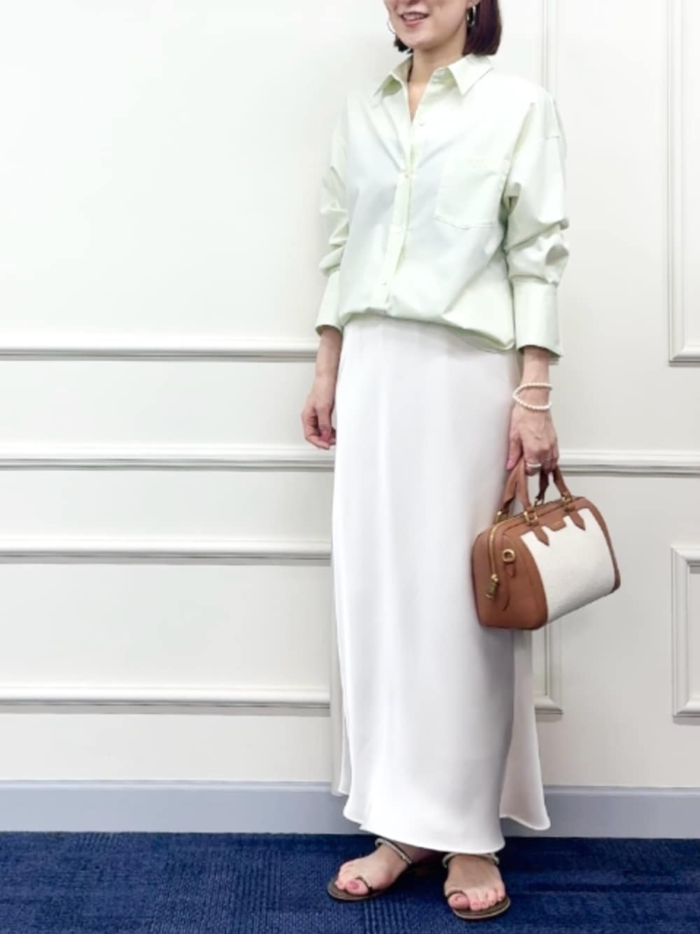 ブラウン系のボストンバッグ、ホワイト系のスカート、グリーン系のシャツ/ブラウスを着用したレディースの冬コーディネートの4枚目の写真