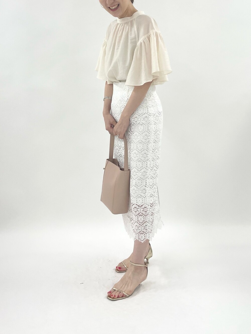 ゴールド系のサンダル、ピンク系のトートバッグ、ホワイト系のシャツ/ブラウスを着用したレディースの春コーディネートの4枚目の写真