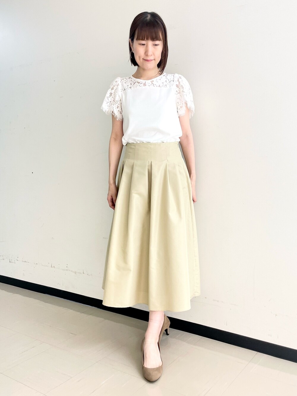 ベージュ系のスカート、ホワイト系のノーカラージャケット、ホワイト系のニット/セーターを着用したレディースの春コーディネートの3枚目の写真