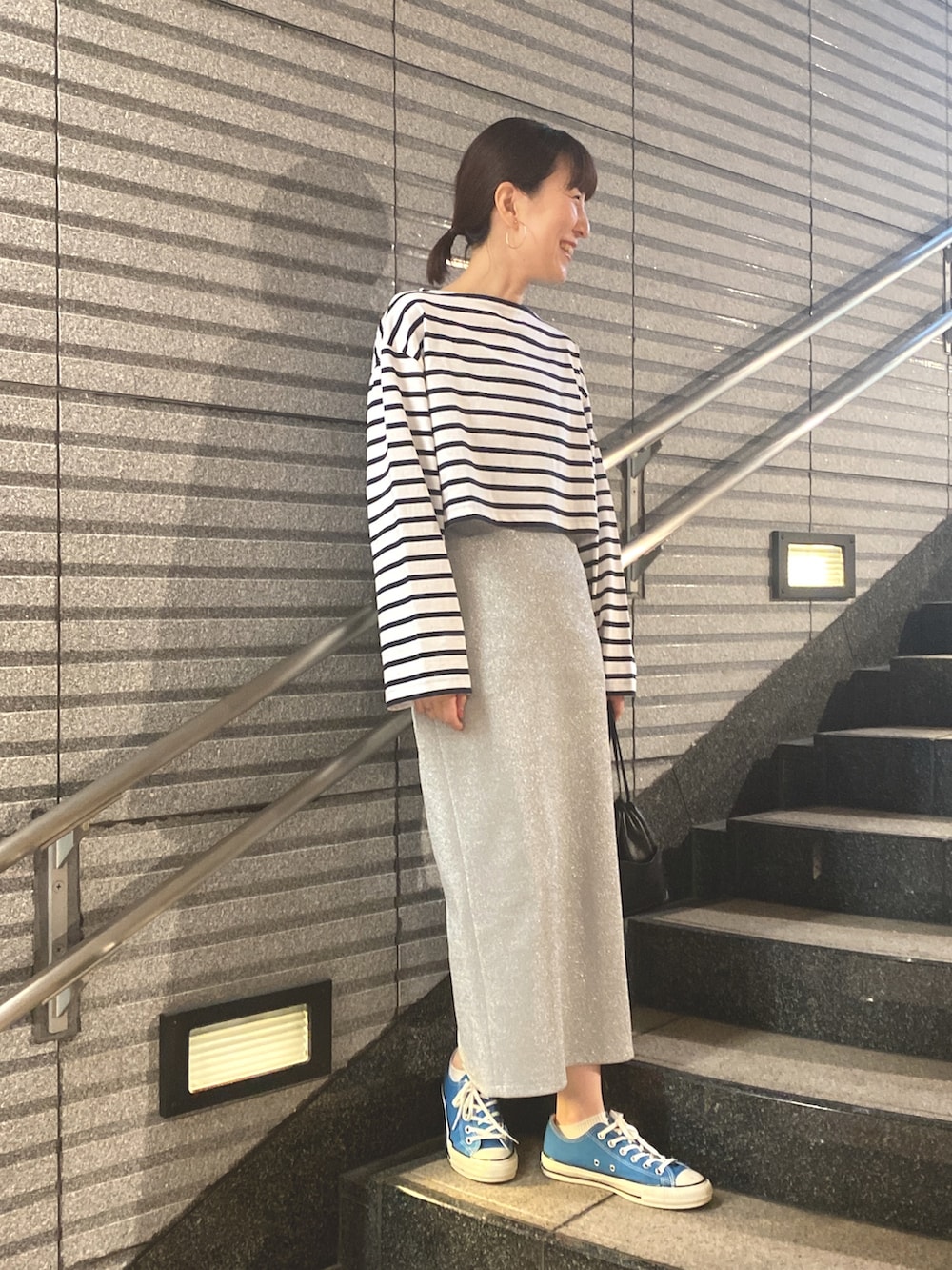 ピンク系のTシャツ/カットソー、シルバー系のスカート、ブルー系のスニーカーを着用したレディースの春コーディネートの3枚目の写真