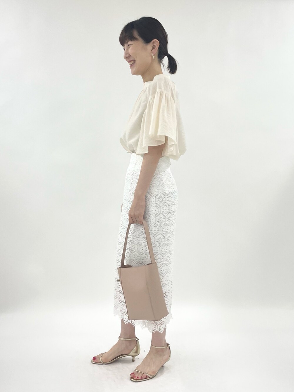 ゴールド系のサンダル、ピンク系のトートバッグ、ホワイト系のシャツ/ブラウスを着用したレディースの春コーディネートの5枚目の写真