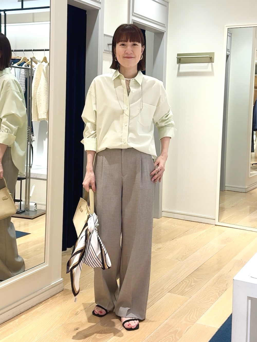 ベージュ系のその他パンツ、ベージュ系のトートバッグ、ホワイト系のシャツ/ブラウスを着用したレディースの春コーディネートの2枚目の写真