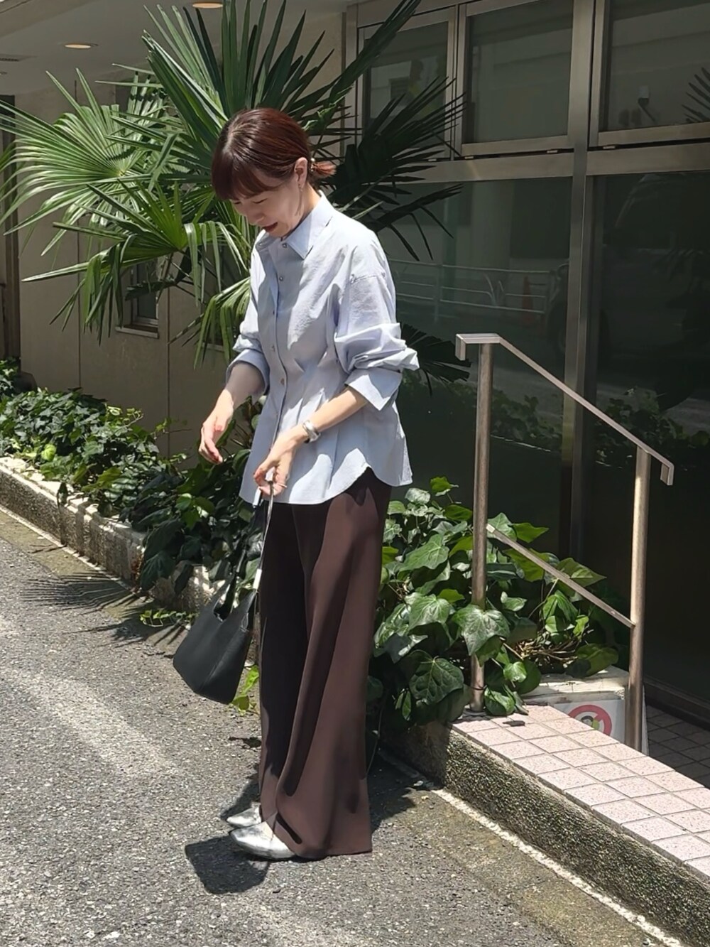 ブラウン系のその他パンツ、ブルー系のシャツ/ブラウス、ブラック系のショルダーバッグを着用したレディースの夏コーディネートの3枚目の写真