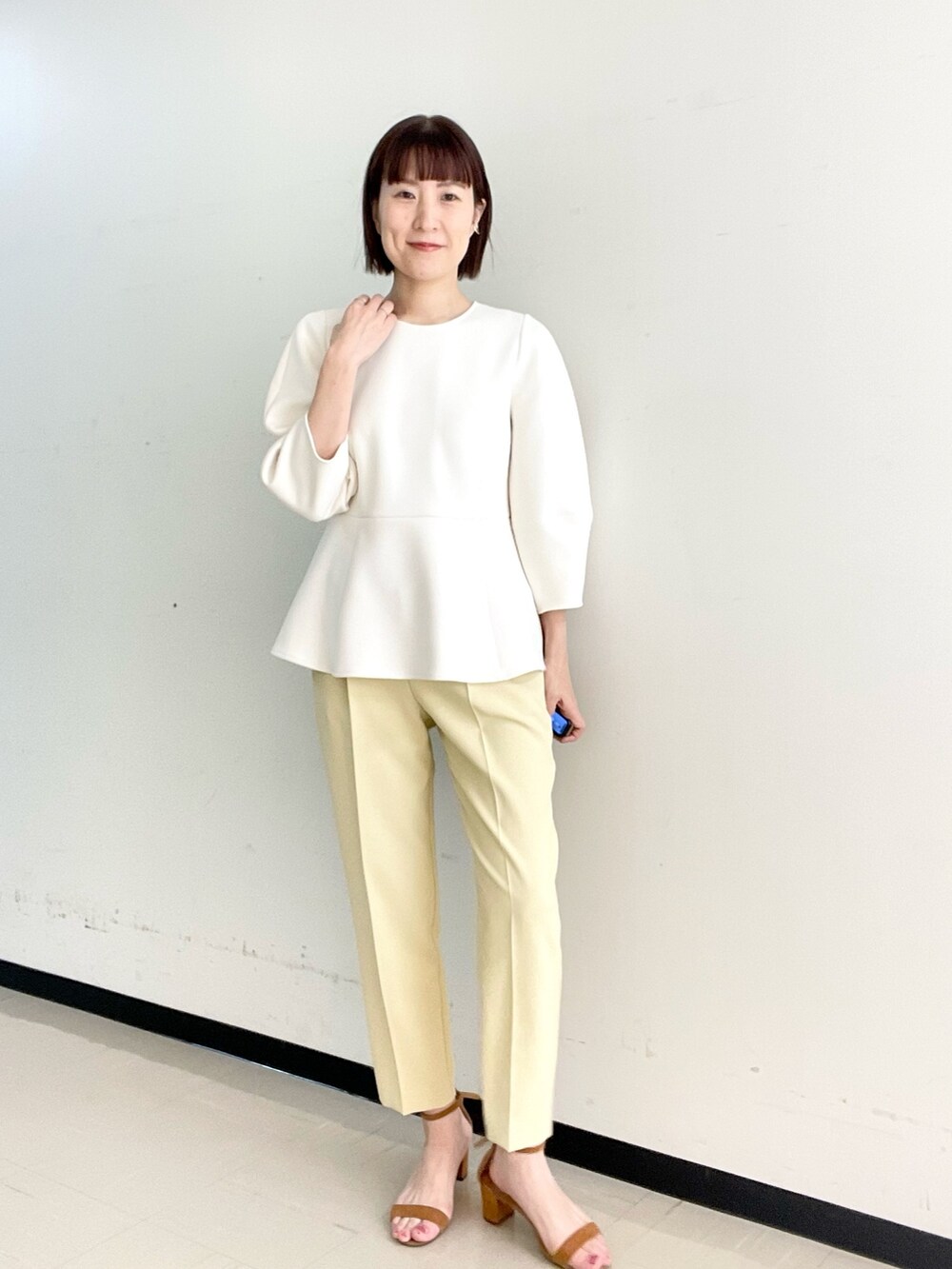 イエロー系のその他パンツ、ホワイト系のTシャツ/カットソー、ゴールド系のイヤーカフを着用したレディースの冬コーディネートの3枚目の写真